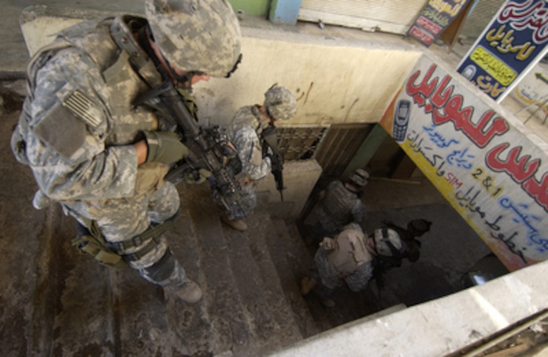 Soldiers from the U.S. Army's 2nd Battalion, 1st Infantry Regiment, 172nd Stryker Brigade Combat Team move down a staircase during a patrol in Mosul, Iraq, on Nov. 2, 2005. The soldiers are patrolling in Mosul in order to disrupt insurgent safe havens and to clear weapons cache sites. 