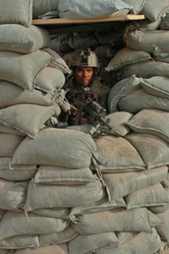 U.S. Army Spc. Wendell Guillermo peers out from his sand bagged position as he provides security in Tal Afar, Iraq, on Oct. 30, 2005. Guillermo is attached to the 2nd Battalion 325th Airborne Infantry Regiment. 