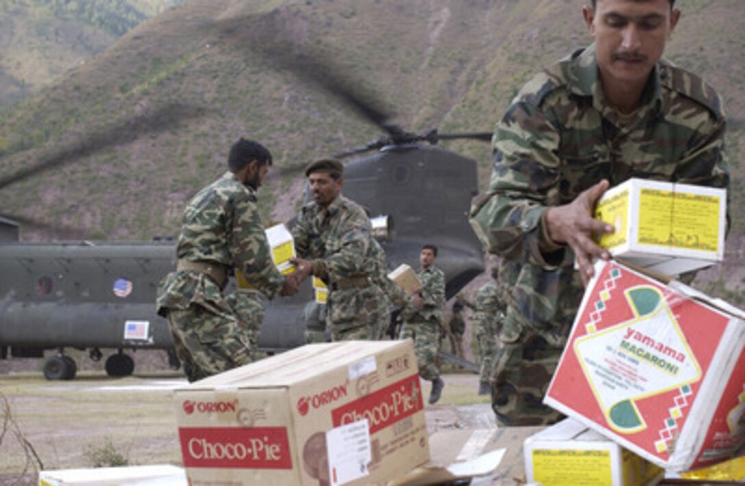 Pakistani soldiers pile boxes of food, tents and other humanitarian relief supplies as they unload a U.S. Army CH-47D Chinook at Devalian, Pakistan, on Nov. 3, 2005. The Department of Defense is supporting the State Department by providing disaster relief supplies and services following the massive earthquake that struck Pakistan and parts of India and Afghanistan. 