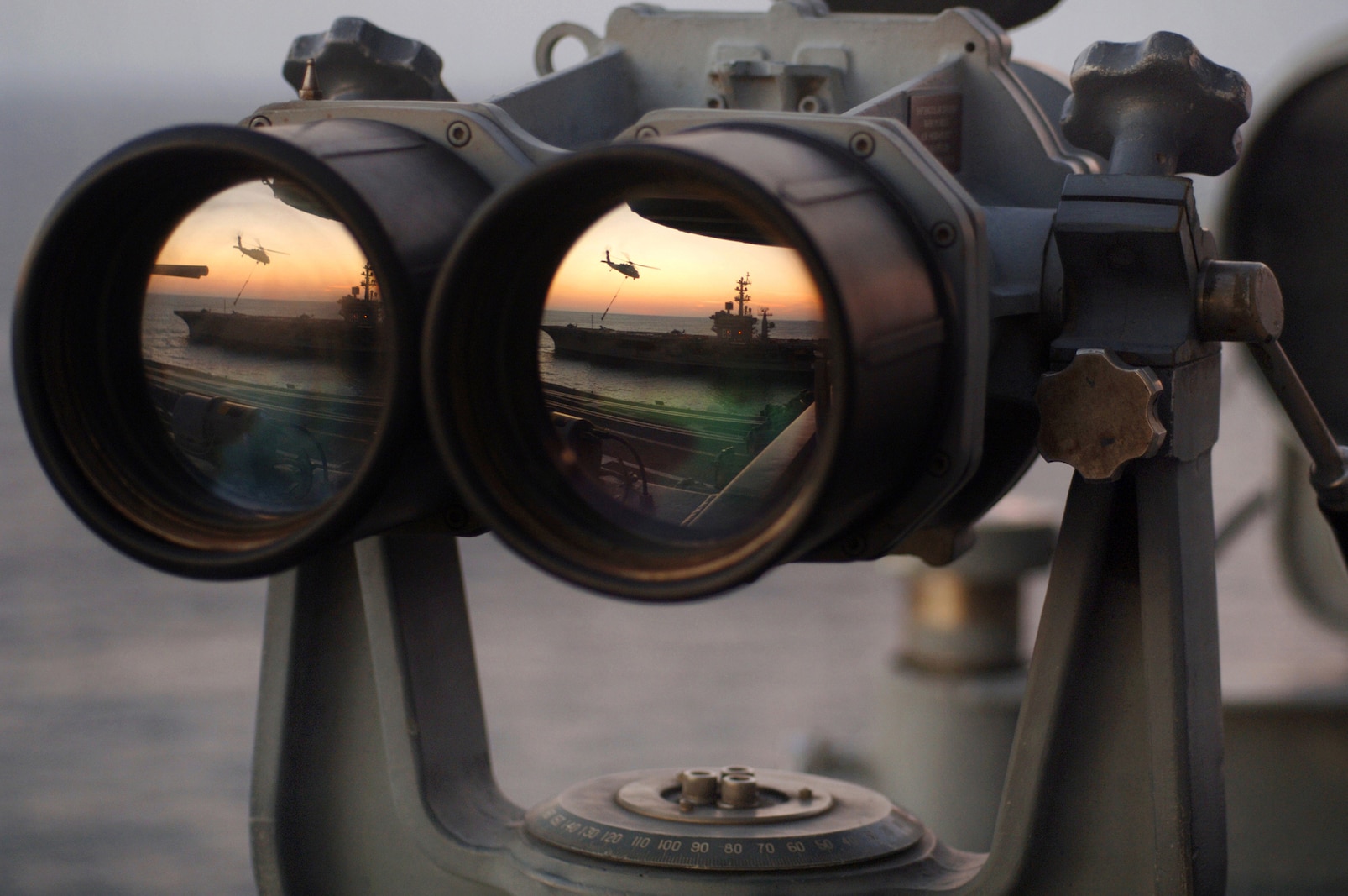 The Nimitz-class aircraft carrier USS Dwight D. Eisenhower (CVN 69) is reflected in a set of "Big Eyes" binoculars on the signal bridge of the Nimitz-class aircraft carrier USS Harry S. Truman (CVN 75). Truman and Eisenhower are currently underway in the Atlantic Ocean conducting ammunition offloads and underway replenishments. U.S. Navy photo by Photographer's Mate Airman Ricardo J. Reyes