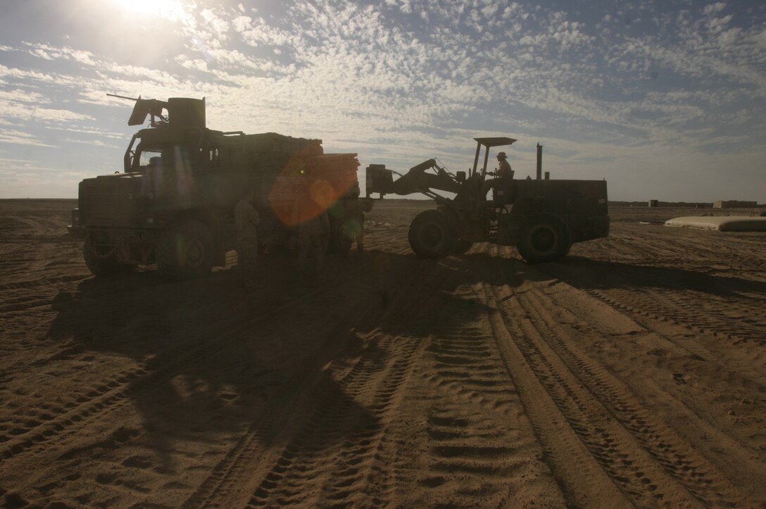 Marines with Transportation Support Company, Combat Logistics Battalion 2, 2nd Marine Logistics Group (Forward), deliver a load of building supplies to a forward operating base near Husaybah, Iraq.