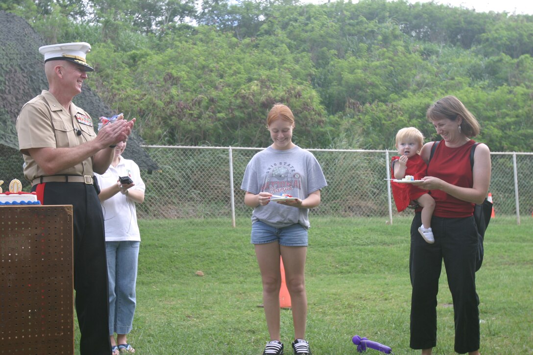 Kaelyn Bridgett, 13, the oldest child to attend the event, passes a slice of cake to Elizabeth Forkin and her daughter, Ella Forkin, 11 months,