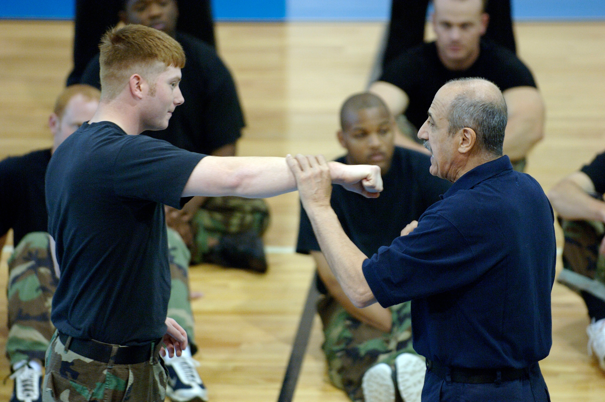 LANGLEY AIR FORCE BASE, Va. (AFPN) -- Master Sgt. John Pellegrini demonstrates proper hand trapping techniques on Senior Airman Cory Rodosevich.  Sergeant Pellegrin a grand master in combat hapkido, teaches the class to improve combat readiness for deploying Airman.  Airman Rodosevich is assigned to the 1st Security Forces Squadron.  (USAF photo by Airman First Class Christopher L. Ingersoll)