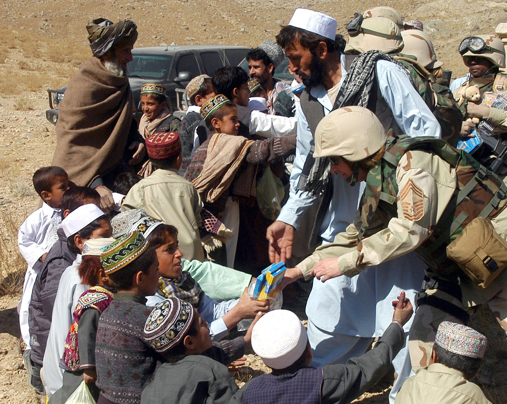 PARWAN PROVINCE, Afghanistan -- Chief Master Sgt. Debra Ballentine and others help distribute school supplies during an adopt-a-village visit here. The Chief is deployed to Bagram Air Base from Travis Air Force Base, Calif. (U.S. Air Force photo by Staff Sgt. Marcus McDonald)           