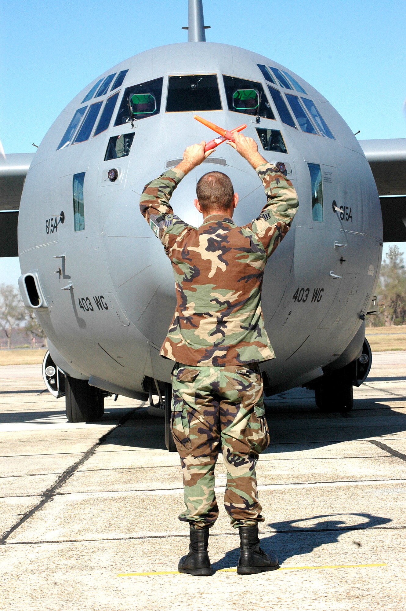 KEESLER AIR FORCE BASE, Miss. (AFPN) -- Senior Airman Mark Fowler guides a C-130J Hercules into its parking spot here. The 403rd Wing mission, which includes the 53rd Weather Reconnaissance Squadron's "Hurricane Hunters" and the 815th Airlift Squadron's "Flying Jennies," fully reinstated its mission at Keesler after Hurricane Katrina damaged their home unit. (U.S. Air Force photo by Tech. Sgt. Chance Babin)