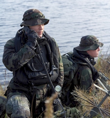 Air Force Combat Controllers make a call to aircraft using thier radios after having penetrate a Florida shoreline with tactical underwater breathing equipment during a training event.   