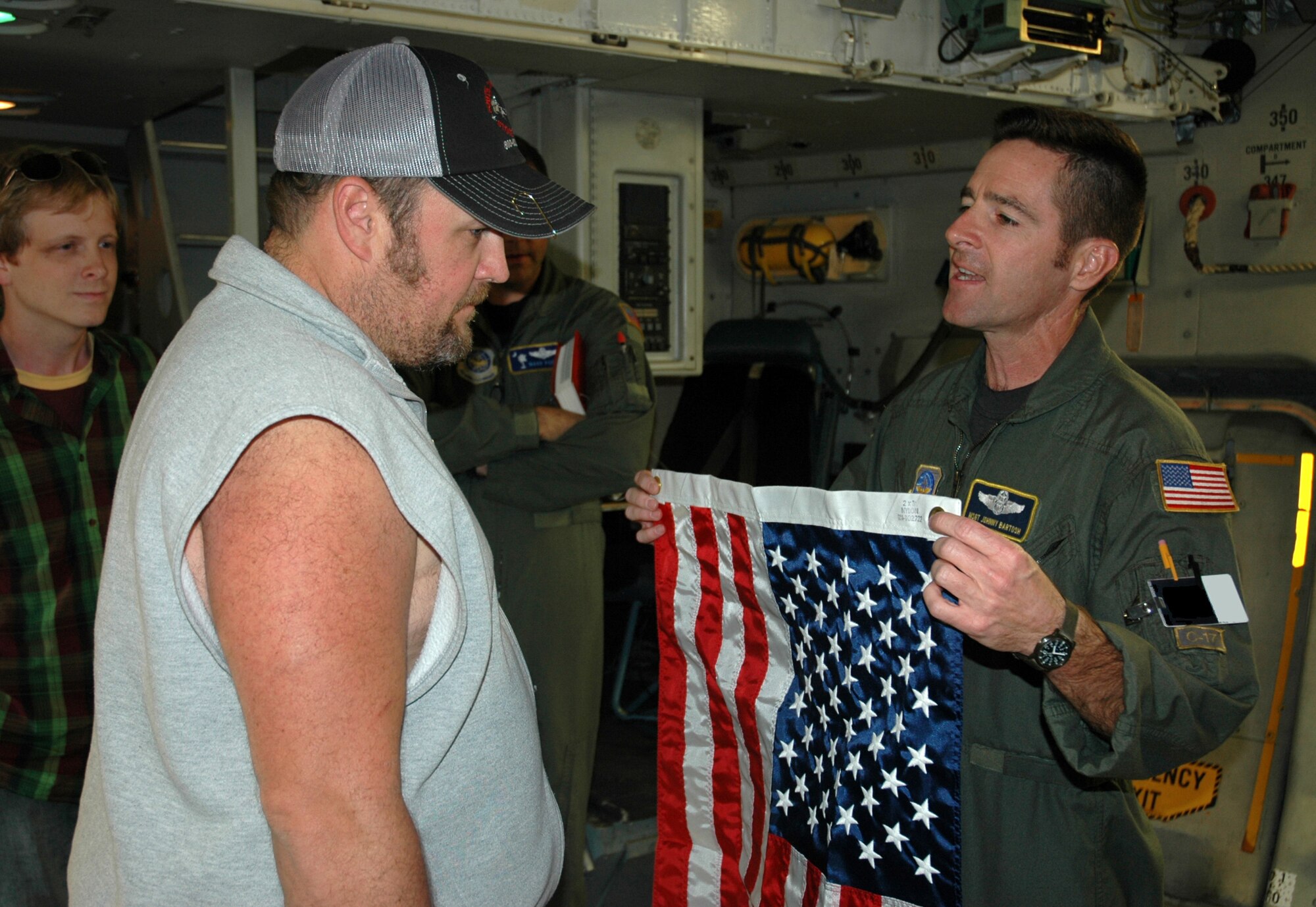 Master Sgt. Johnny Bartosh, a loadmaster assigned to Air Force Reserve Commands 701st Airlift Squadron, Charleston Air Force Base, S.C., presents comedian Larry the Cable Guy with a U.S. flag. The comedian toured Charleston AFB and visited with active-duty and Air Force Reserve men and women to show his support for the troops defending America. (U.S. Air Force photo by 1st Lt. Wayne Capps)

