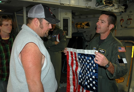 Master Sgt. Johnny Bartosh, a loadmaster assigned to Air Force Reserve Commands 701st Airlift Squadron, Charleston Air Force Base, S.C., presents comedian Larry the Cable Guy with a U.S. flag. The comedian toured Charleston AFB and visited with active-duty and Air Force Reserve men and women to show his support for the troops defending America. (U.S. Air Force photo by 1st Lt. Wayne Capps)

