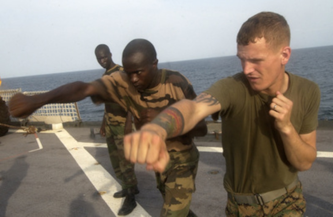 U.S. Marine Corps Lance Cpl. Chuck Myers (right) trains a Senegalese Navy infantryman in Marine Corps Martial Arts aboard the USS Gunston Hall (LSD 44) on Nov. 3, 2005. The training is part of West African Training Cruise 06, which enhances security cooperation and fosters new partnerships between the United States, North Atlantic Treaty Organization partners, and participating West African nations through real-world training and engagement opportunities. Myers is attached to Charlie Company, 1st Battalion, 8th Marine Regiment of Camp Lejeune, N.C. 