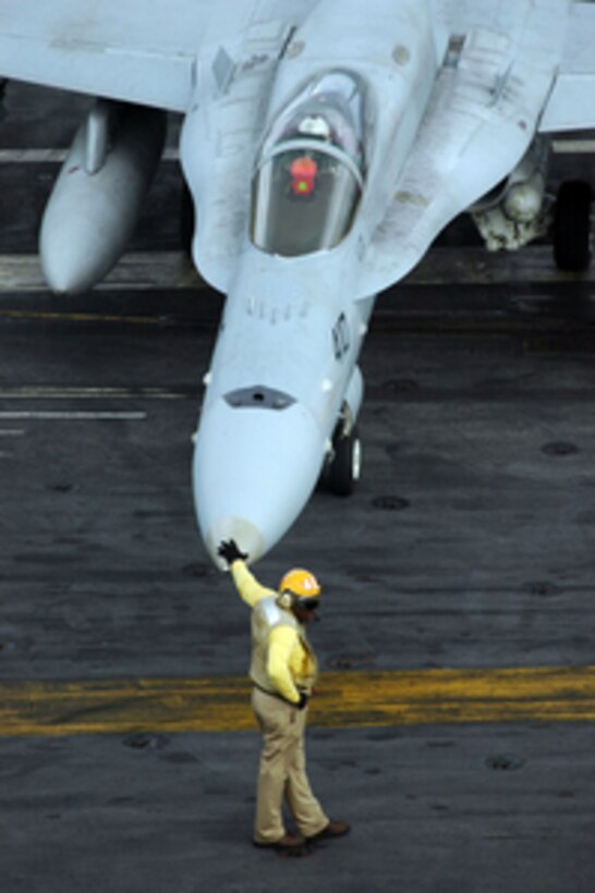 U.S. Navy Lt. Adrian Turner leans on the nose of an F/A-18C as he monitors the movement of flight deck personnel during flight operations aboard the aircraft carrier USS Kitty Hawk (CV 63) on Nov. 3, 2005. The Kitty Hawk Carrier Strike Group is operating in the western Pacific Ocean from its homeport of Yokosuka, Japan. 