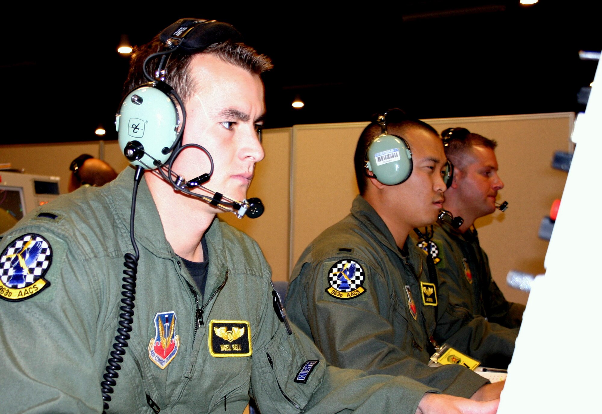 KIRTLAND AIR FORCE BASE, N.M. (AFPN) -- 1st Lts. Nigel Bell (left) and Jerrad Brown (center) work to control the aerial battlespace during exercise Virtual Flag 06 at the Distributed Mission Operations Center here. The lieutenants completed this mission Nov. 3 and are both from the 963rd Airborne Air Control Squadron. (U.S. Air Force photo by 1st Lt. Nathan D. Broshear)