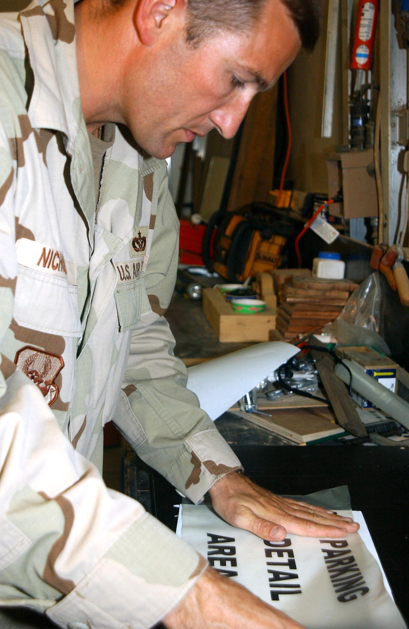 SOUTHWEST ASIA (AFPN) -- Master Sgt. Stephen Nicholas creates a parking sign for one of the facilities here.  To create signs, Sergeant Nicholas designs the lettering on a computer, cuts sheet metal to an appropriate size and shape, then applies the lettering and protective laminate.  Sergeant Nicholas and other structural maintenance technicians maintain and repair hundreds of buildings here.  He is an Air Force Reservist deployed from Selfridge Air National Guard Base, Mich. (U.S. Air Force photo by Tech. Sgt. Mike Hammond)
