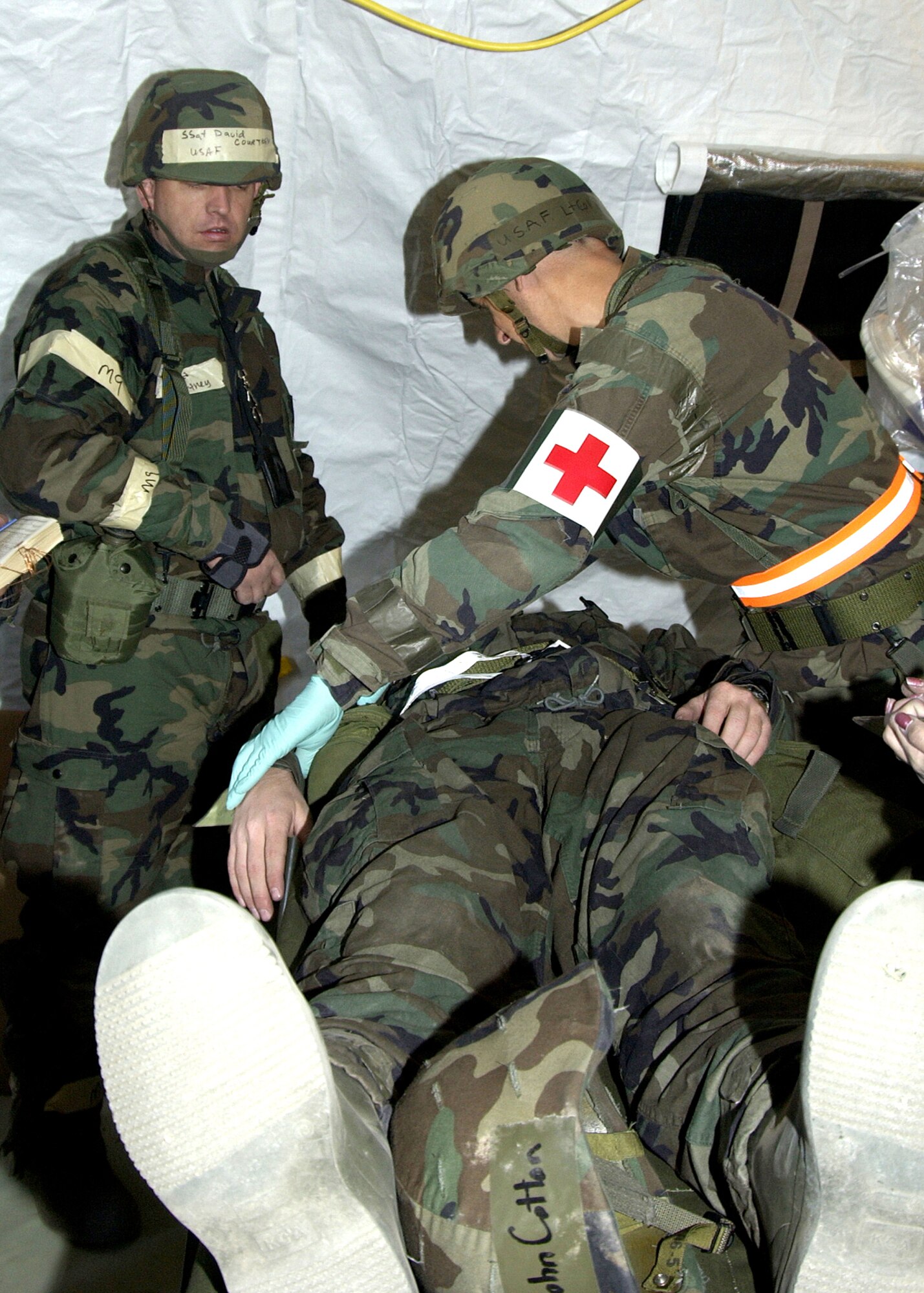 DAVIS-MONTHAN, Ariz. (AFPN) -- 1st Lt. John Cotton receives medical attention for a simulated head wound from Lt. Col. Gary Hurwitz and other members of the 355th Medical Group during exercise Bushwhacker 06-01 here.  (U.S. Air Force photo by Veronica Pierce) 


