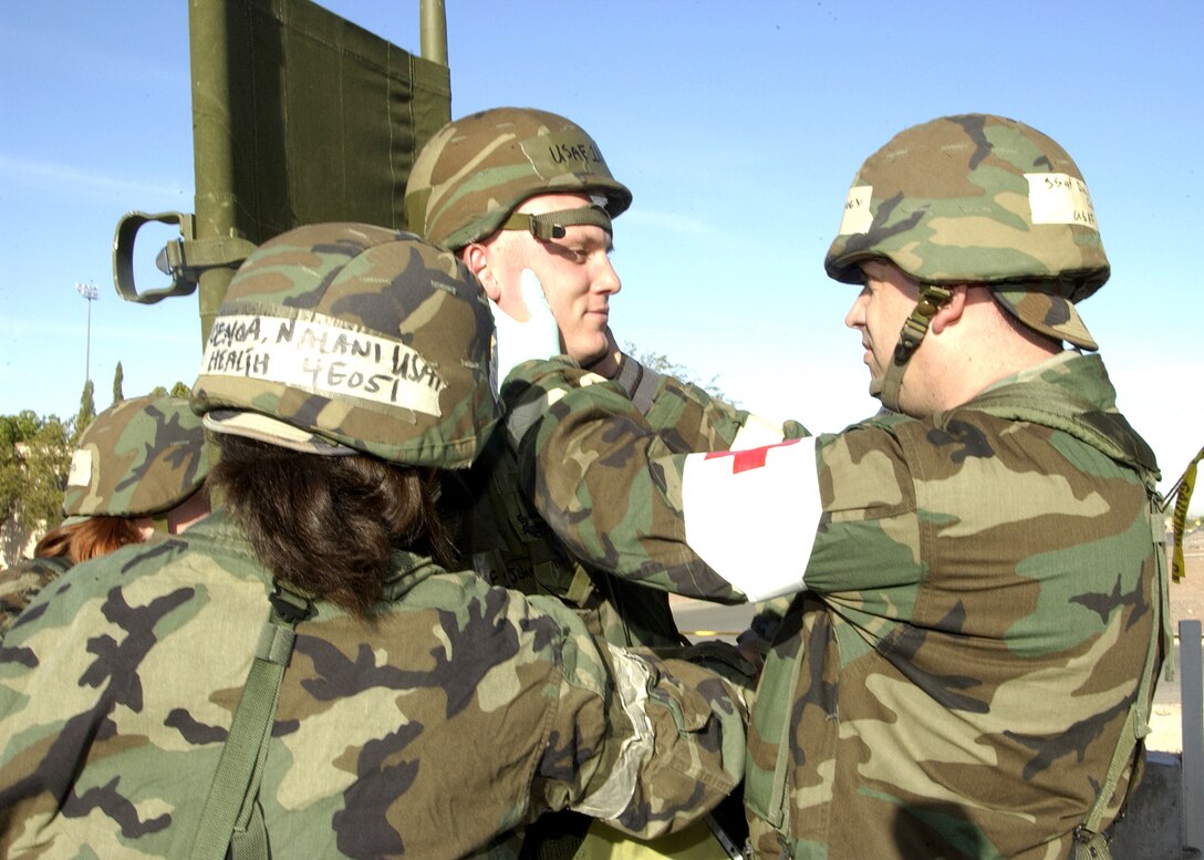 DAVIS-MONTHAN, Ariz. (AFPN) -- 1st Lt. John Cotton receives medical attention for a simulated head wound from members of the 355th Medical Group during exercise Bushwhacker 06-01 here.  Lieutenant Cotton is with the 355th Logistics Readiness Squadron. (U.S. Air Force photo by Veronica Pierce) 