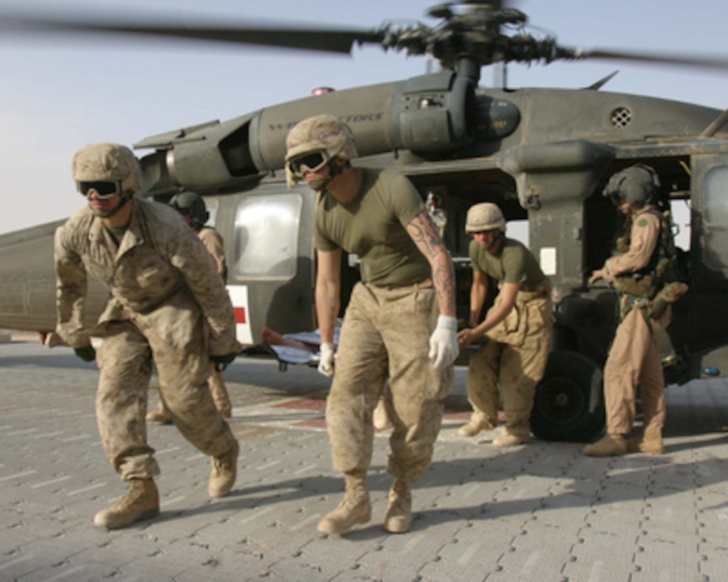 U.S. Marines from the 3rd Battalion, 6th Marine Regiment Motor Transport unload a wounded Marine from an Army UH-60 Blackhawk helicopter for medical treatment at Al Qaim, Iraq, on Nov. 7, 2005. The Blackhawk is attached to the Army's 571st Medical Company Air Ambulance. 