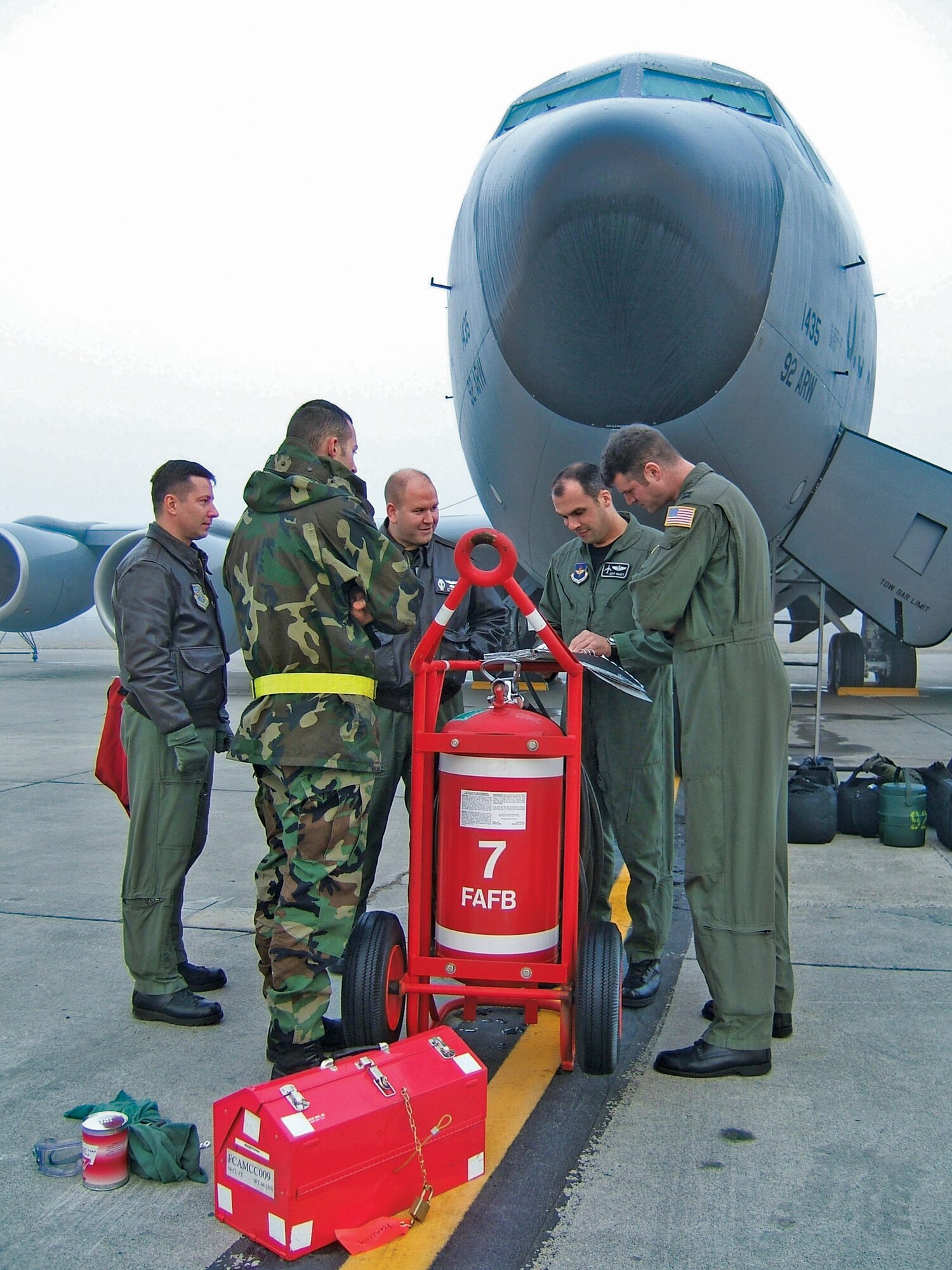 FAIRCHILD AIR FORCE BASE, Wash. -- Captains Jay Butterfield and Jeff Paget (left and far left), and 509th Weapons Squadron cadre, review a KC-135 Stratotanker's maintenance records with a crew chief from the 92nd Aircraft Maintenance Squadron. The captains are KC-135 Weapons Instructor Course students at the squadron here. (U.S. Air Force photo by Shadi May)