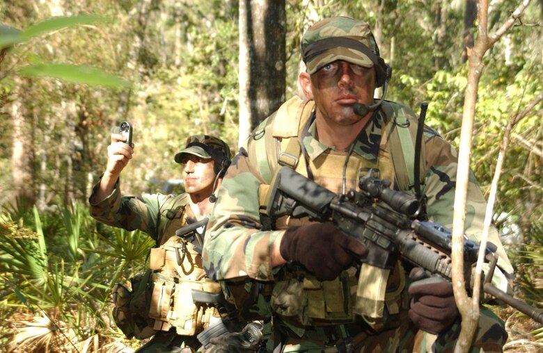 Staff Sgt. Jody Ball, 10th Combat Weather Squadron, scans the surrounding area for threats while Tech Sgt. Rick Rohde, 10th CWS, collects weather data during a training exercise held near Hurlburt Field, Fla.