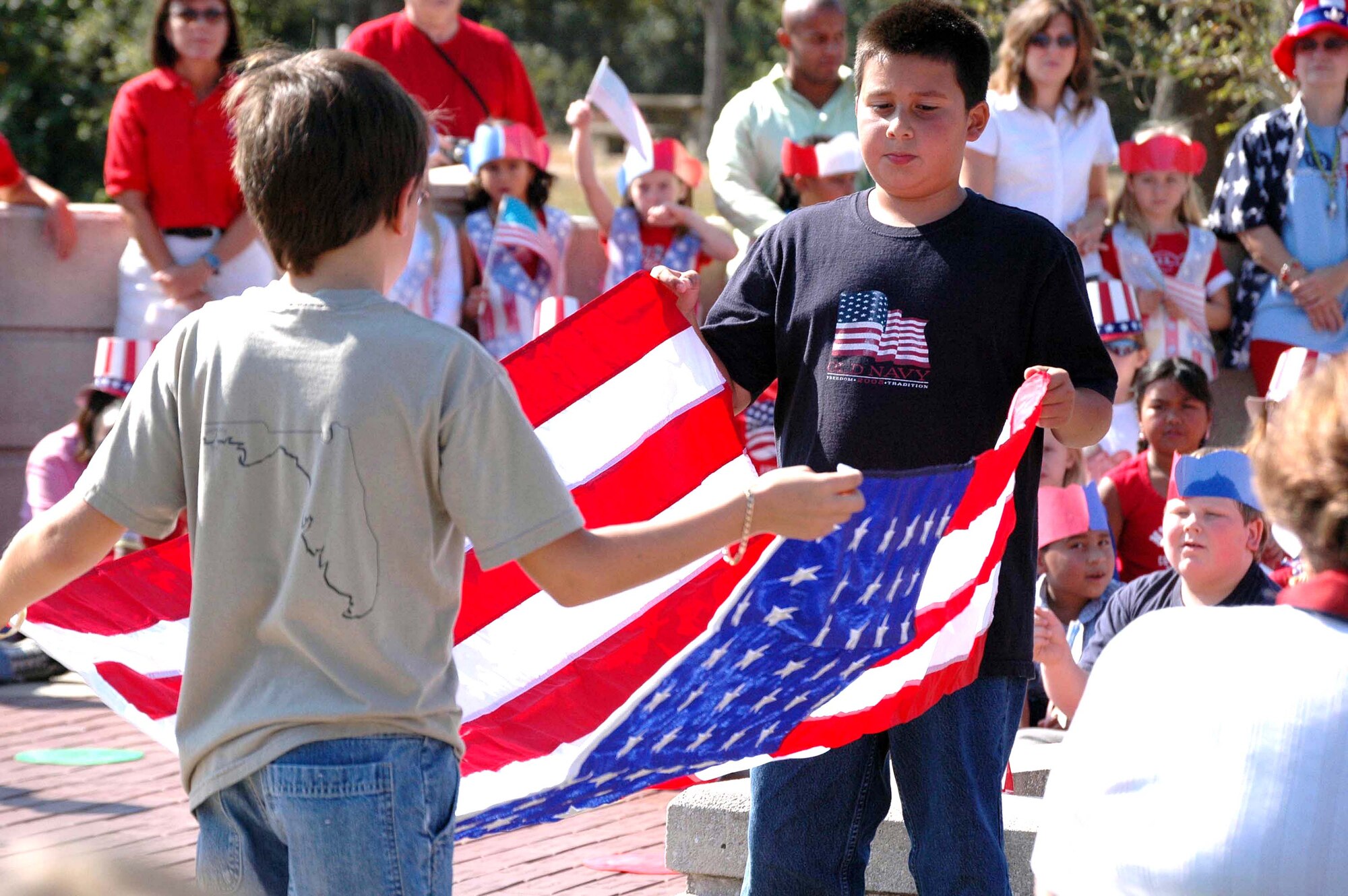 EGLIN AIR FORCE BASE, Fla. (AFPN) -- Fifth-graders Seth Rodriguez and Tyler Schrack fold the American flag during Oak Hill Elementary Schools Veterans Day walk. Oak Hill students have been doing the walk for 30 years. (U.S. Air Force photo by Lois Walsh)