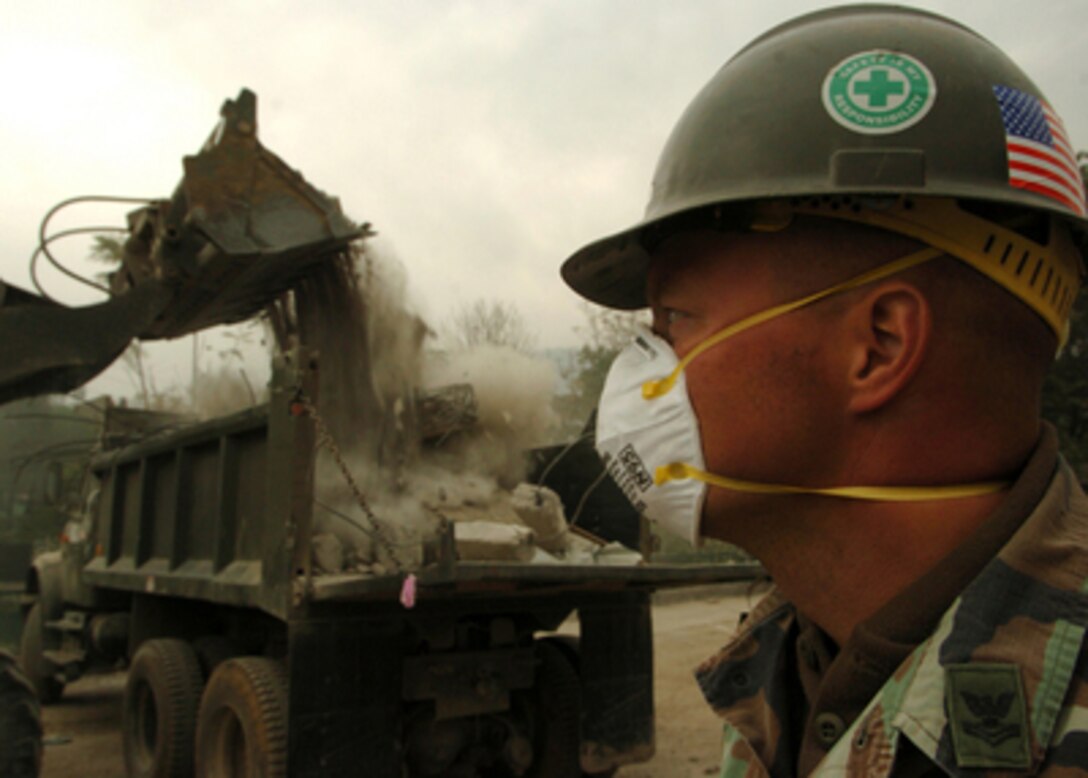 U.S. Navy Seabee Petty Officer 2nd Class Peter Frederickson monitors debris removal at the Army Public School in Muzaffarabad, Pakistan, on Nov. 10, 2005. Frederickson is a Navy equipment operator attached to Naval Mobile Construction Battalion 74, deployed from Gulfport, Miss. The Department of Defense is supporting the State Department by providing disaster relief supplies and services following the massive earthquake that struck Pakistan and parts of India and Afghanistan. 