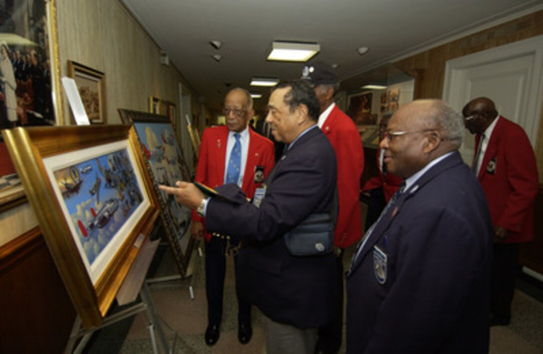 Tuskegee Airman and former 2nd Lt. William Wheeler (center) points out a detail of an oil painting depicting some of the history of the Tuskegee Airmen to retired Master Sgt. Ezra Hill (right) and former Staff Sgt. Phillip W. Broome (left) in the Pentagon on Nov. 10, 2005. Wheeler, Hill, Broome, and their fellow airmen are at the Pentagon to receive briefings on the state of the Air Force, an update on global operations and have lunch with Rumsfeld. During World War II, the Tuskegee Airmen were credited with destroying 261 aircraft, damaging 148 aircraft, flying 15,553 combat sorties and 1,578 missions over Italy and North Africa. They destroyed or damaged over 950 units of ground transportation and escorted more than 200 bombing missions. As an escort fighter wing during World War II, they never lost a bomber to enemy fighters. 