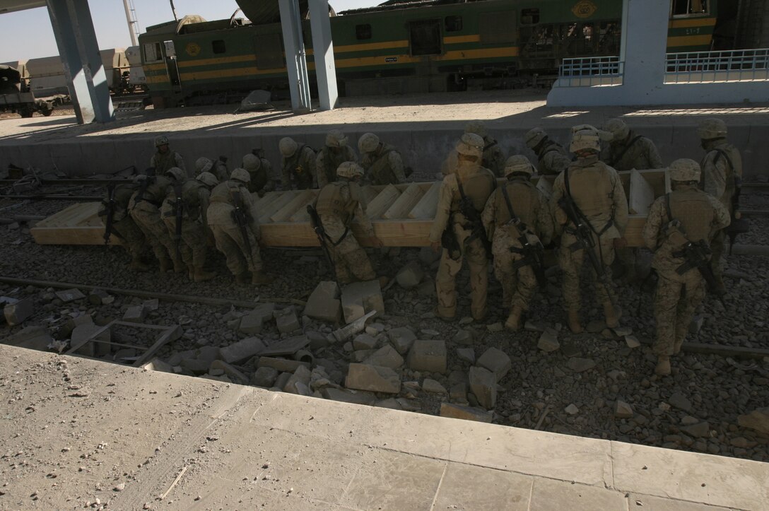 Combat engineers assigned to Combat Logistics Battalion 2, 2nd Marine Logistics Group (Forward), position a staircase they constructed to access a scout position at a forward operating base in the city of Husaybah, Iraq.