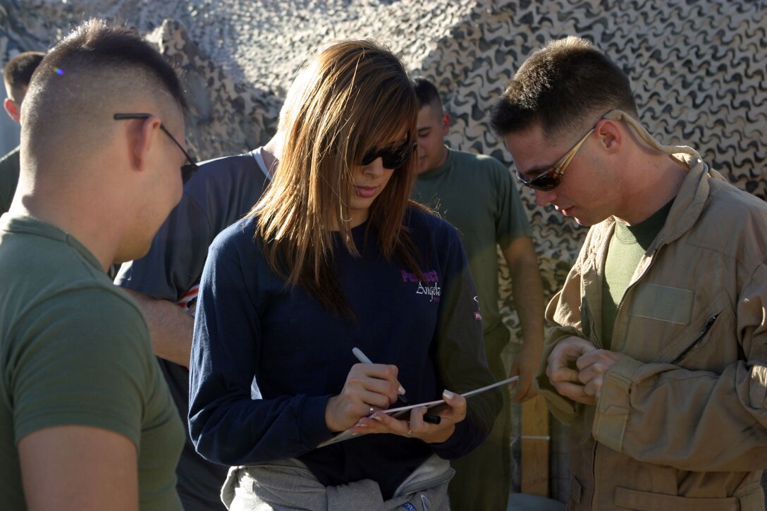 CAMP TAQADDUM, Iraq (Nov. 14, 2005) ?   Tanea Brooks signs a poster for Marines with Marine Medium Helicopter Squadron 161, 2nd Marine Aircraft Wing (Fwd.) here Nov 14. The ?Purrfect Angelz?, a dance and performance group from Los Angeles, met with and performed for service members deployed in support of Operation Iraqi Freedom.