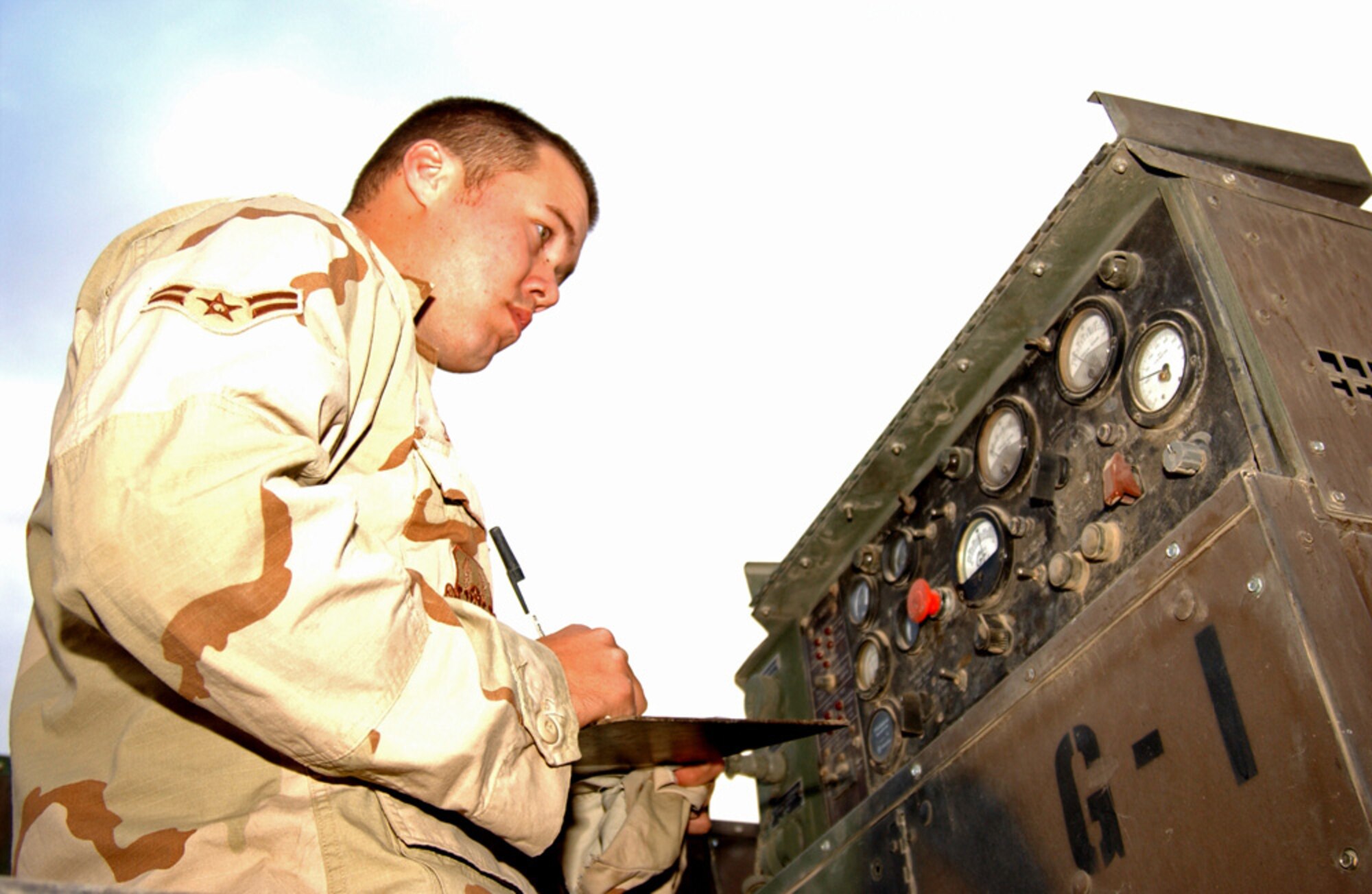 BALAD AIR BASE, Iraq (AFPN) -- Airman 1st Class Mark Baugh, 727th Expeditionary Air Control Squadron, documents a generator inspection. The generators outside of the compound here are inspected every three hours. Airman Baugh is with the 727th Expeditionary Air Control Squadron. (U.S. Air Force photo by Staff Sgt. Tammie Moore)                       