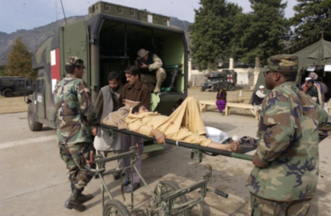 Members of the U.S. Army's 212th Mobile Army Surgical Hospital load a Pakistani woman into a ambulance after being treated for a shattered pelvis at Muzaffarabad, Pakistan, on Nov. 12, 2005. The Department of Defense is supporting the State Department by providing disaster relief supplies and services following the massive earthquake that struck Pakistan and parts of India and Afghanistan. 