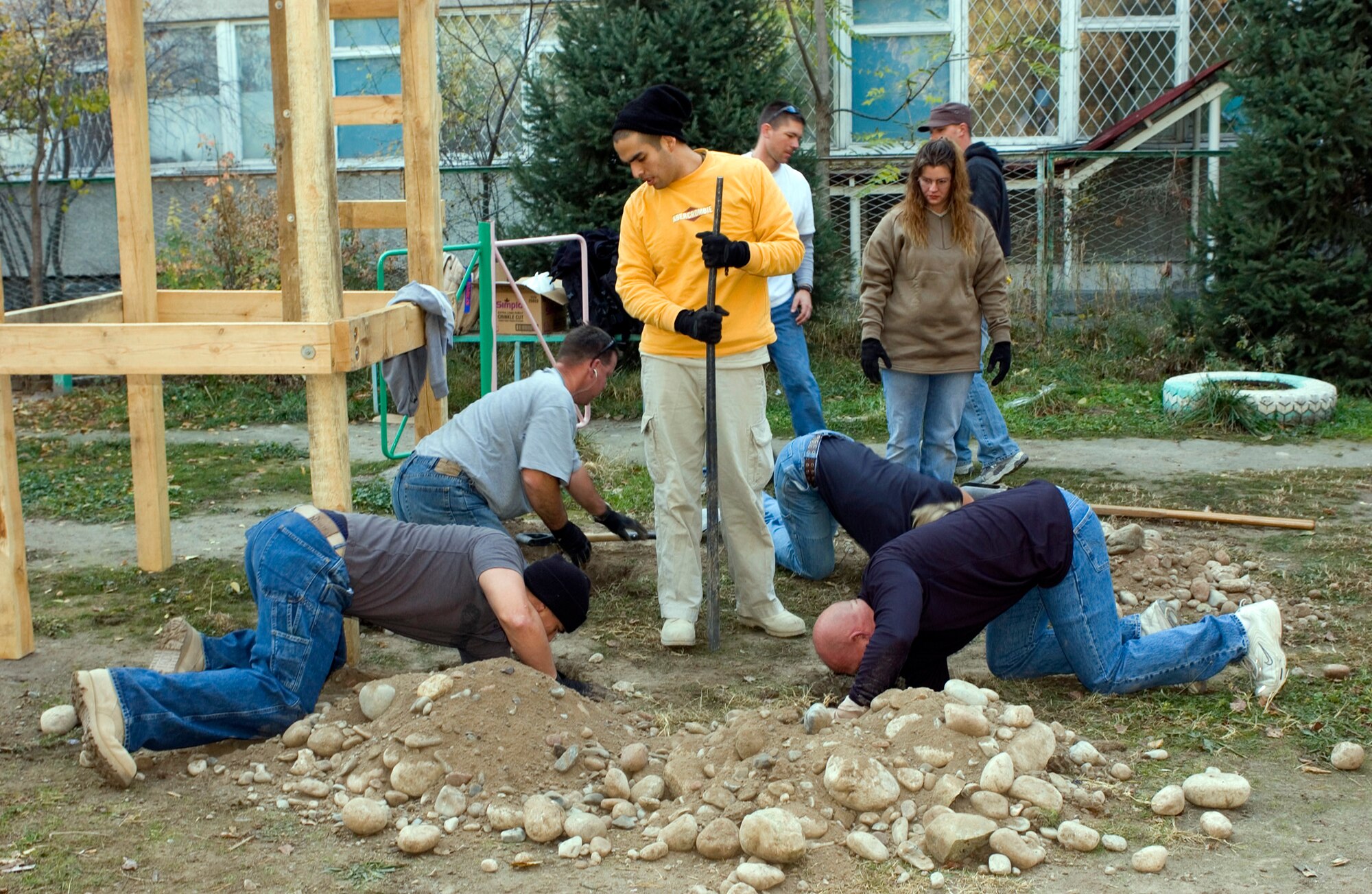 BISHKEK, Kyrgyzstan (AFPN) -- Airmen of the Manas Air Base Outreach Society dig holes in the rocky soil outside the children's cancer center to anchor a new play fort they donated. The Airmen volunteer their day off to do the work at the center. (U.S. Air Force photo by Robin Hicks)
