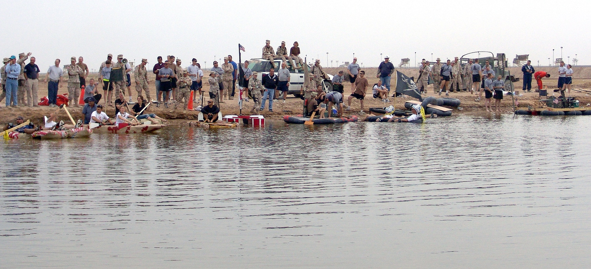 CAMP BUCCA, Iraq (AFPN) -- Two-person rafting teams wait for the start of the first-ever Camp Bucca Raft Race. More than 17 Air Force, Army and Navy teams  participated in the Nov. 13 event. The Army's "Team Wilson," made up of Staff Sergeant Fawn Armstrong and Mark Khoury, finishing first. They won more than $100 worth of Army and Air Force Exchange Service merchandise. (U.S. Air Force photo by Tech. Sgt. Mark Getsy)