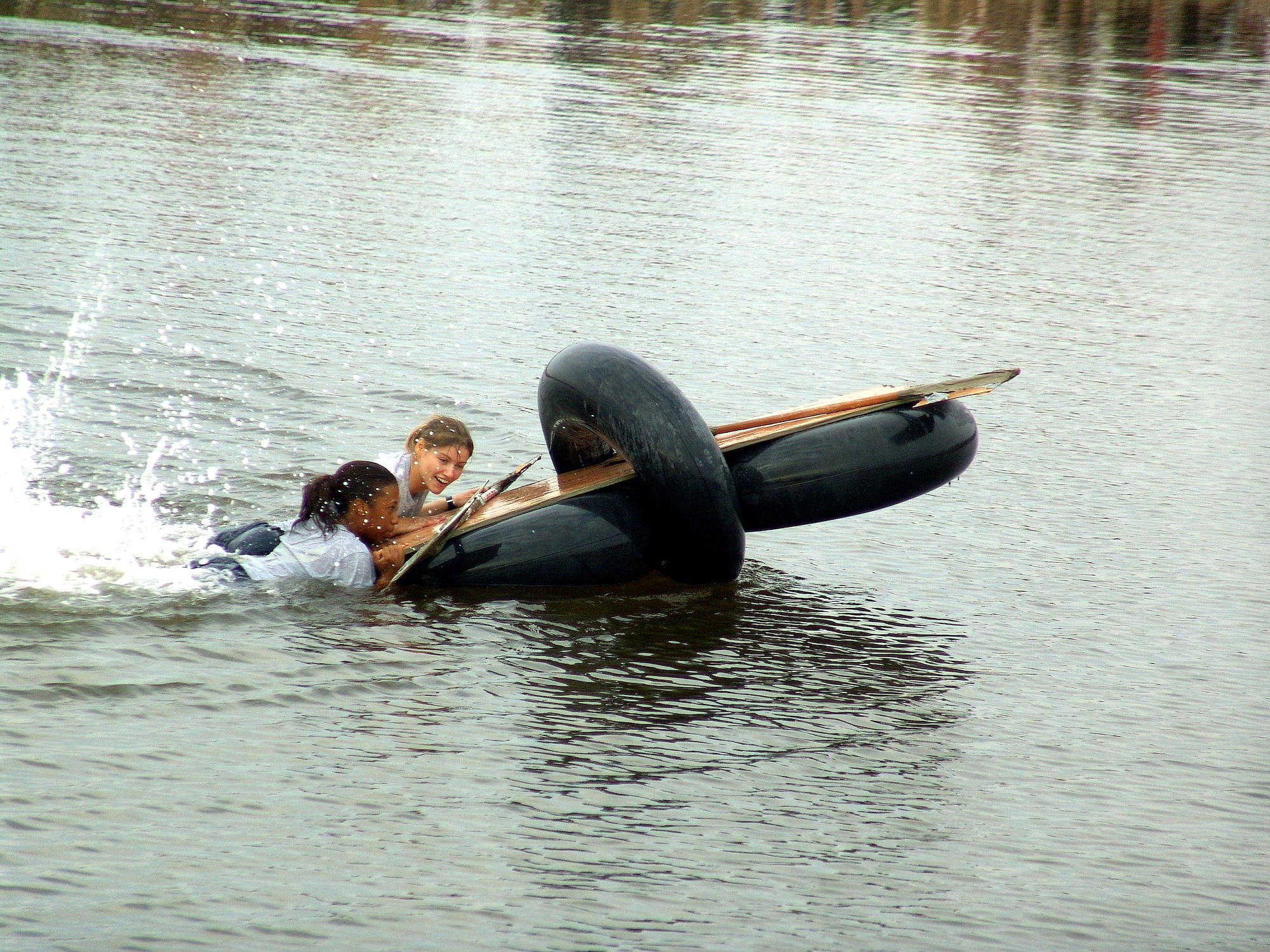 CAMP BUCCA, Iraq (AFPN) -- Staff Sgt. Ashanti Charles and Airman 1st Class Christie Swehle resorted to kicking their way back to shore when their boat did not finish the first-ever Camp Bucca Raft Race. The 886th Expeditionary Security Forces Squadron troops made up one of 17 teams to enter the event -- held on a small pond here Nov. 13. Both Airmen are deployed from Langley Air Force Base, Va. (U.S. Air Force photo by Tech. Sgt. Mark Getsy)
