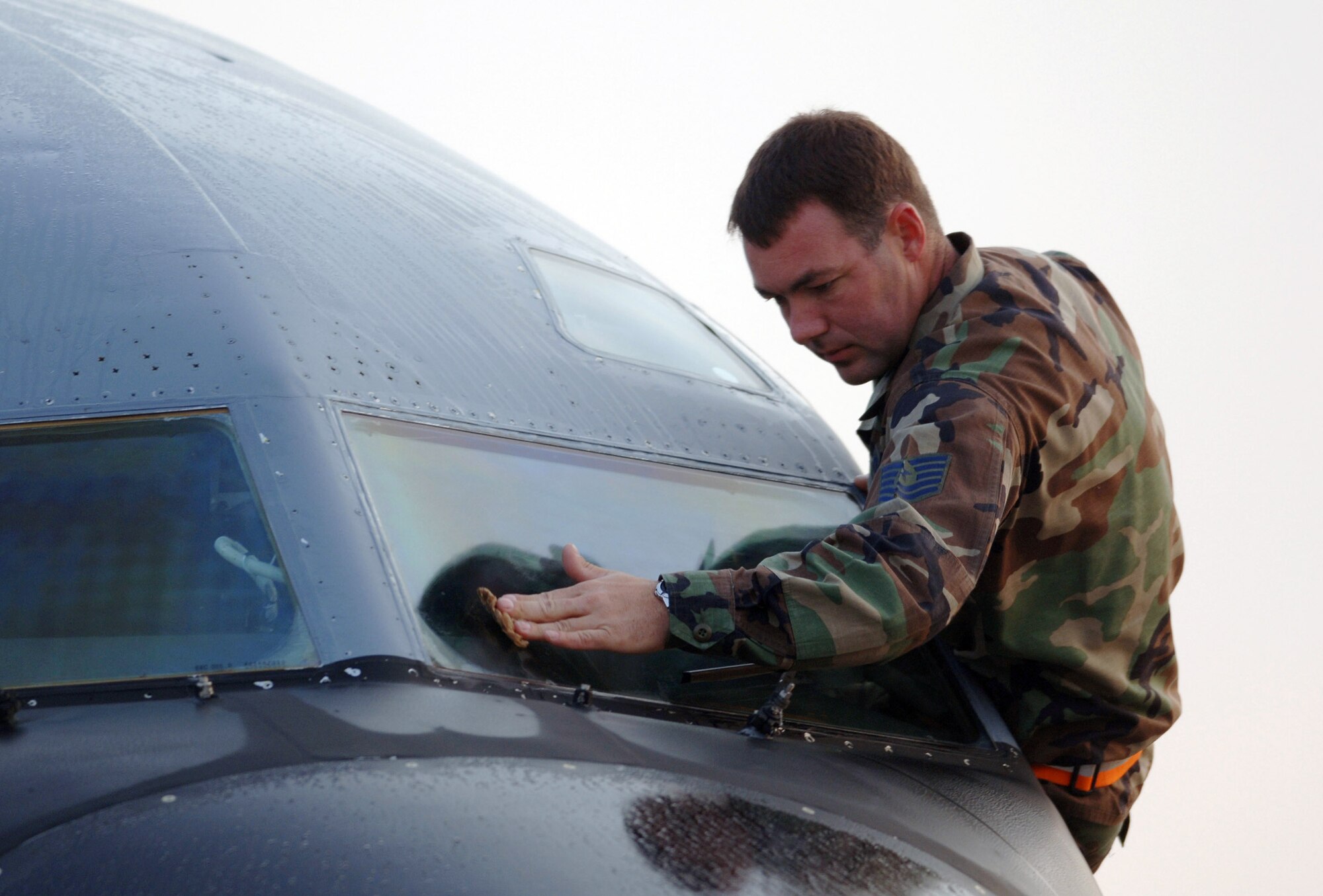 YOKOTA AIR BASE, Japan (AFPN) -- Crew chief Tech. Sgt. Julian Christian cleans the windshield of his KC-135 Stratotanker before an exercise Cope North 05 morning sortie. Cope North is a bilateral exercise designed to enhance U.S. and Japanese air operations. It gives pilots from both countries opportunities to conduct training in air combat tactics, electronic combat and airborne air control. Sergeant Christian is with the 718th Aircraft Maintenance Squadron here. (U.S. Air Force photo by Master Sgt. Val Gempis)