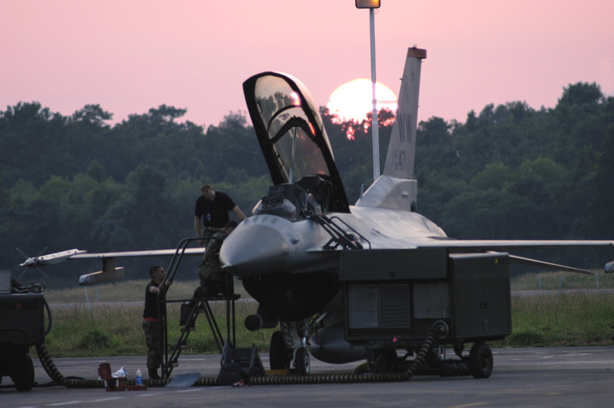 KALAIKUNDA AIR STATION, India (AFPN) -- Staff Sgts. Lyle Janey and Allen Conard and Senior Airman Sean Mcelree put the finishing touches on an F-16 Fighting Falcon as the sun sets over Cope India 06.  Halfway through the exercise, U.S. aircraft had flown 97 sorties with their Indian air force counterparts. The Airmen are all avionics specialists deployed here from the 35th Aircraft Maintenance Squadron, Misawa Air Base, Japan. (U.S. Air Force photo by Tech Sgt. Martin Jackson) 