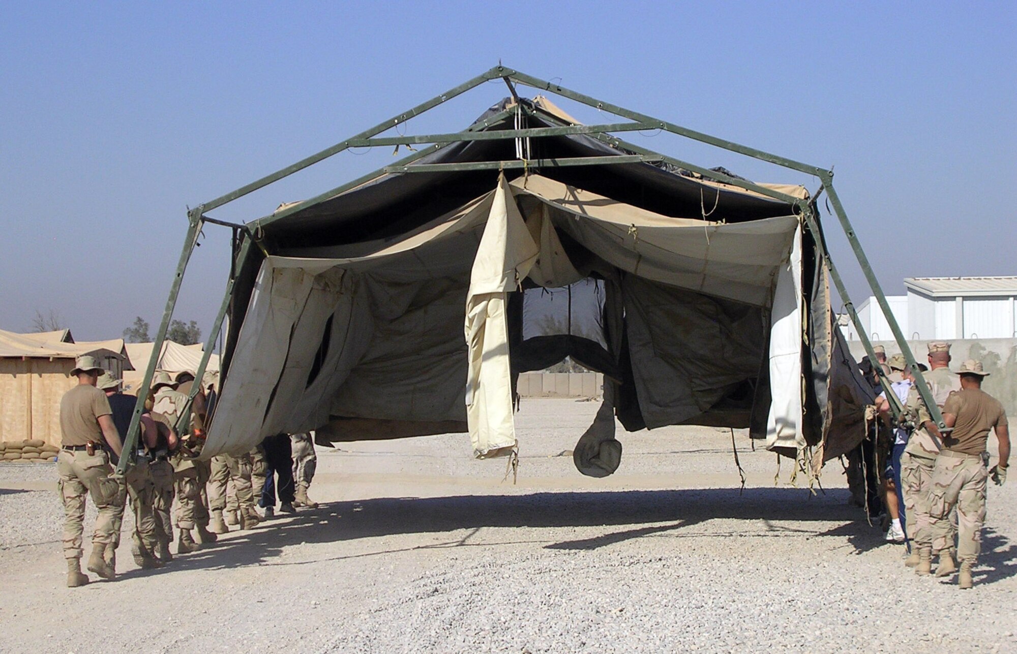 ALI BASE, Iraq (AFPN) -- Taking Air and Space Expeditionary Force doctrine literally, Airmen move their tent to a new location at this base. When the 407th Air Expeditionary Group needed space for a new services facility, 407th Expeditionary Civil Engineer Squadron troops and volunteers simply picked up the tent that stood in the way and moved it to a new spot 200 yards away. That saved the several hour it would have taken to tear down and set the tent back up .  (U.S. Air Force photo by Master Sgt. Terry Swartz) 
