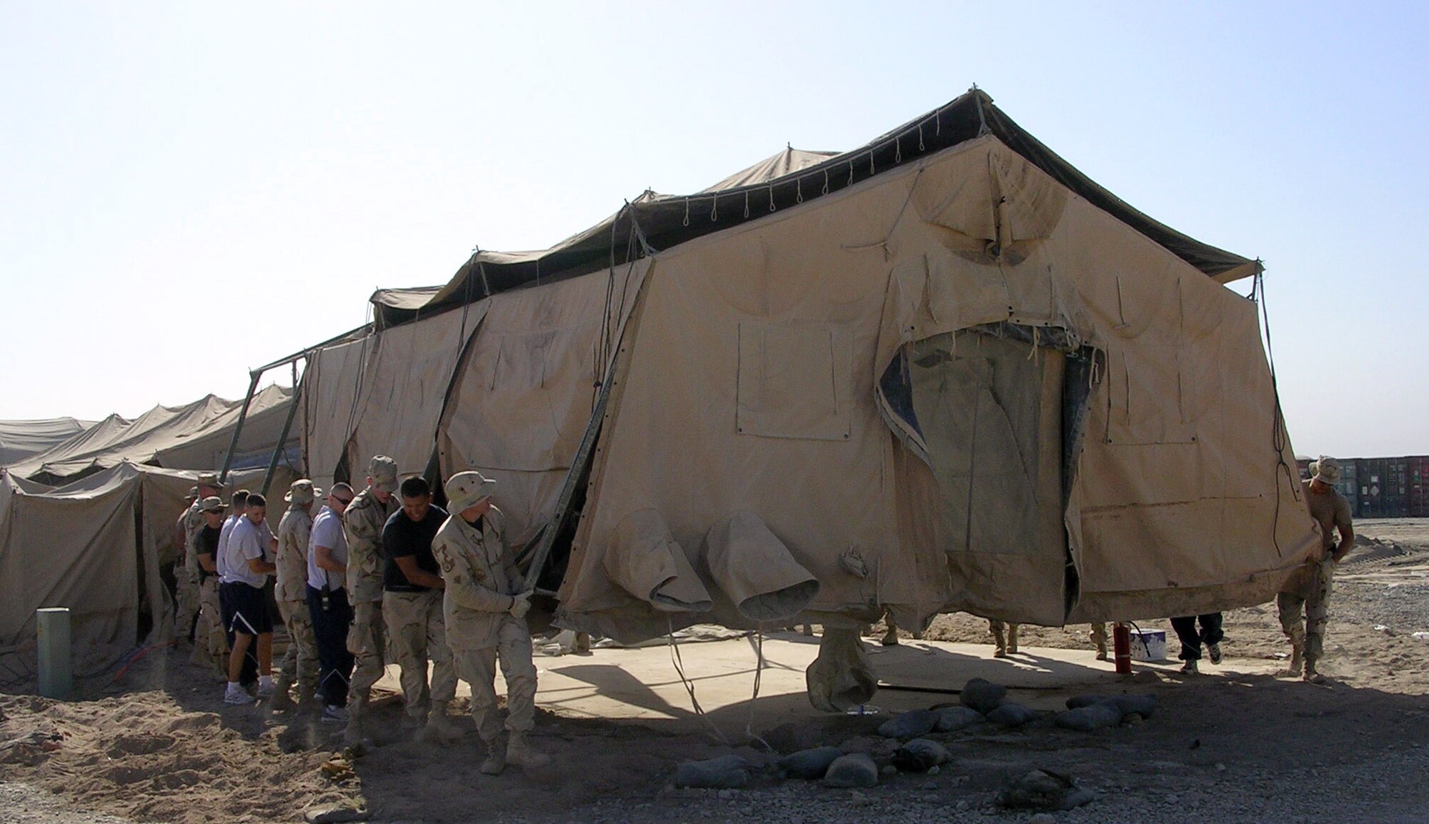 ALI BASE, Iraq (AFPN) -- Taking Air and Space Expeditionary Force doctrine literally, Airmen move their tent to a new location at this base. When the 407th Air Expeditionary Group needed space for a new services facility, 407th Expeditionary Civil Engineer Squadron troops and volunteers simply picked up the tent that stood in the way and moved it to a new spot 200 yards away. That saved the several hour it would have taken to tear down and set the tent back up .  (U.S. Air Force photo by Master Sgt. Terry Swartz) 
