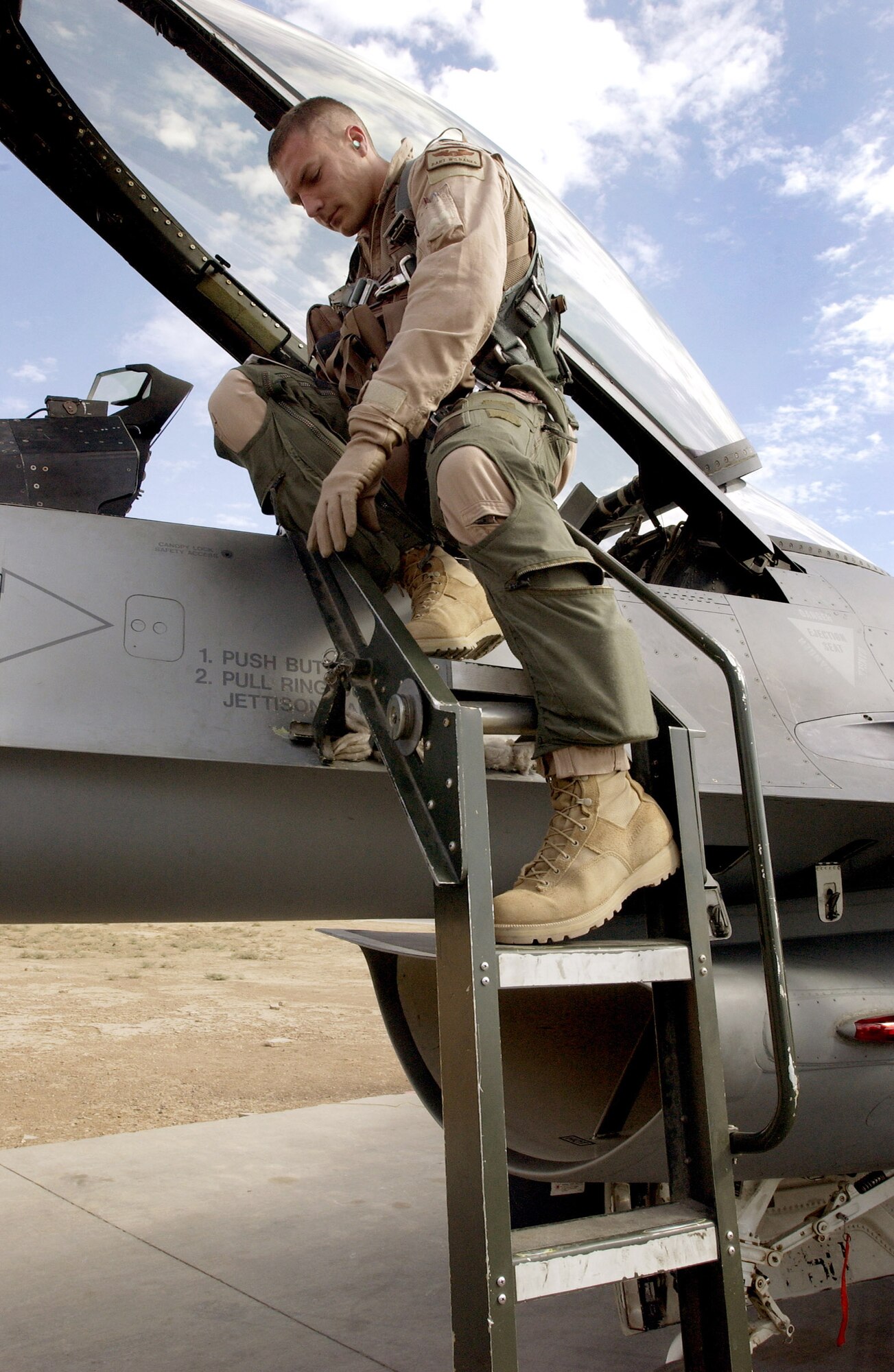 BALAD AIR BASE, Iraq (AFPN) -- Capt. Bart Wilbanks climbs down from the cockpit of his F-16 Fighting Falcon after completing a successful close air-support mission over Mosul. Captain Wilbanks is from Waco, Texas, and deployed to this base from the 555th Fighter Squadron, Aviano Air Base, Italy. (U.S. Army photo by Staff Sgt. Timothy Lawn) 