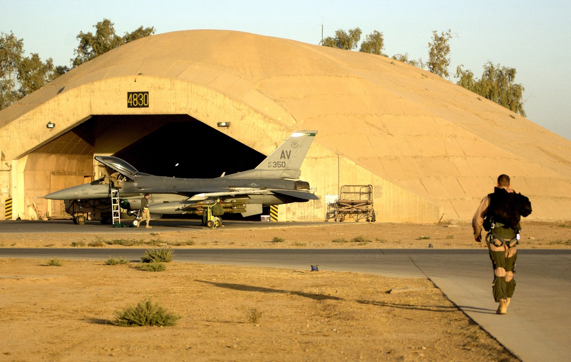 BALAD AIR BASE, Iraq (AFPN) -- Capt. Bart Wilbanks walks to his F-16 Fighting Falcon as maintainers prepare it for an early morning close-air support mission over Mosul, Iraq. Captain Wilbanks is from Waco, Texas, and deployed to this base from the 555th Fighter Squadron, Aviano Air Base, Italy. (U.S. Army photo by Staff Sgt. Timothy Lawn)