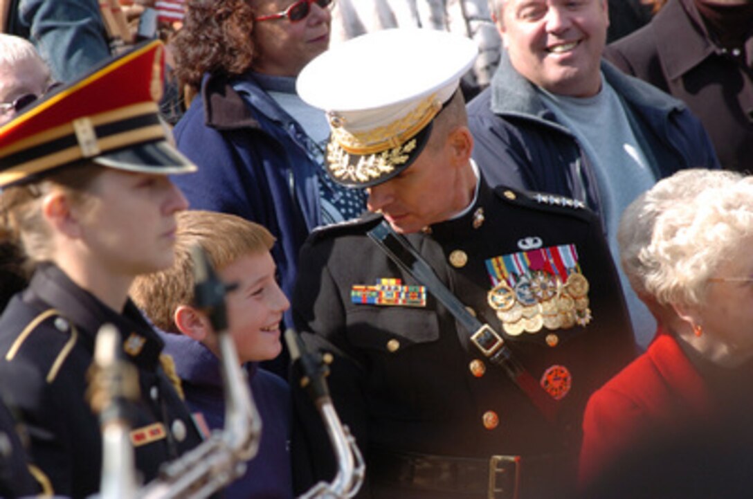 Chairman of the Joint Chiefs of Staff Gen. Peter Pace, U.S. Marine Corps, talks to a young man in the audience at the Veterans Day wreath ceremony at the Tomb of the Unknown Soldier in Arlington National Cemetery, Arlington, Va. on Nov. 11, 2005. 
