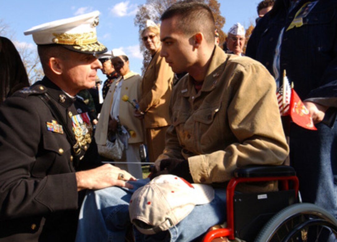 Chairman of the Joint Chiefs of Staff Gen. Peter Pace, U.S. Marine Corps, talks with a Marine, wounded in Operation Iraqi Freedom, at the Vietnam Veterans Memorial Wall in Washington, D.C., on Nov. 11, 2005. Pace was the keynote speaker at the annual Veterans Day ceremony at the Wall. 
