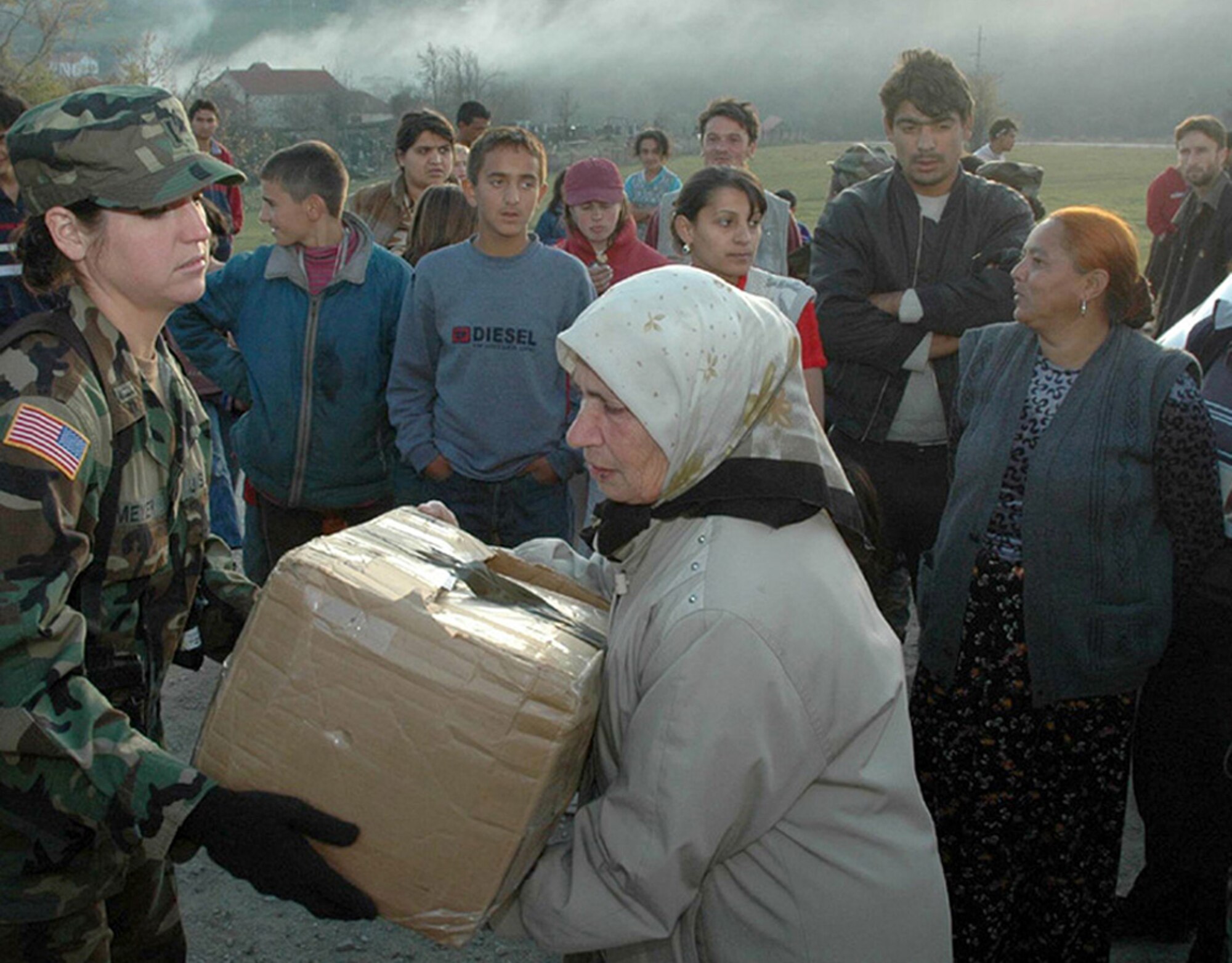 NOVO BRDO, Kosovo (AFPN) -- 1st Lt. Melanie Meyer gives a box of items to a resident of Novo Brdo during a U.S. forces humanitarian mission. Lieutenant Meyer is in charge of coordinating the monthly missions. She is the Headquarters Kosovo Force Public Information Liaison Officer. (Ukranian Army photo by 1st Lt. Maksym Nedria) 