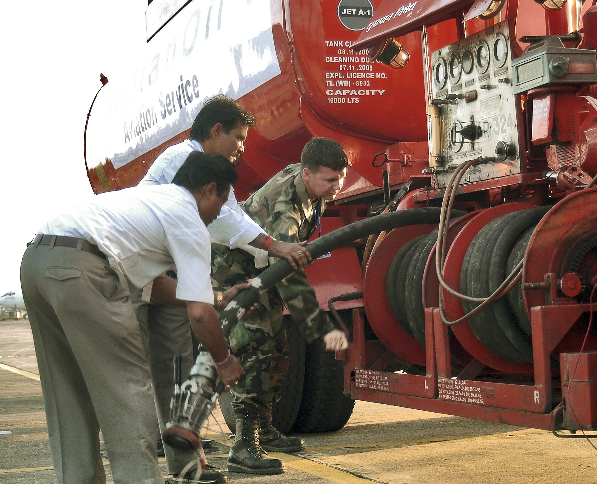 KALAIKUNDA AIR STATION, India (AFPN) -- Staff Sgt. Trey Norris reels in a fueling hose after the refueling an F-16 Fighting Falcon during Cope India 2006. During the exercise, Sergeant Norris has worked closely with the Indian Oil Company to completing 146 aircraft refuels -- nearly 235,000 gallons of fuel. Sergeant Norris is a fuels distribution supervisor from the 374th Logistics Readiness Squadron at Yokota Air Base, Japan. (U.S. Air Force photo by Tech. Sgt. Martin Jackson)