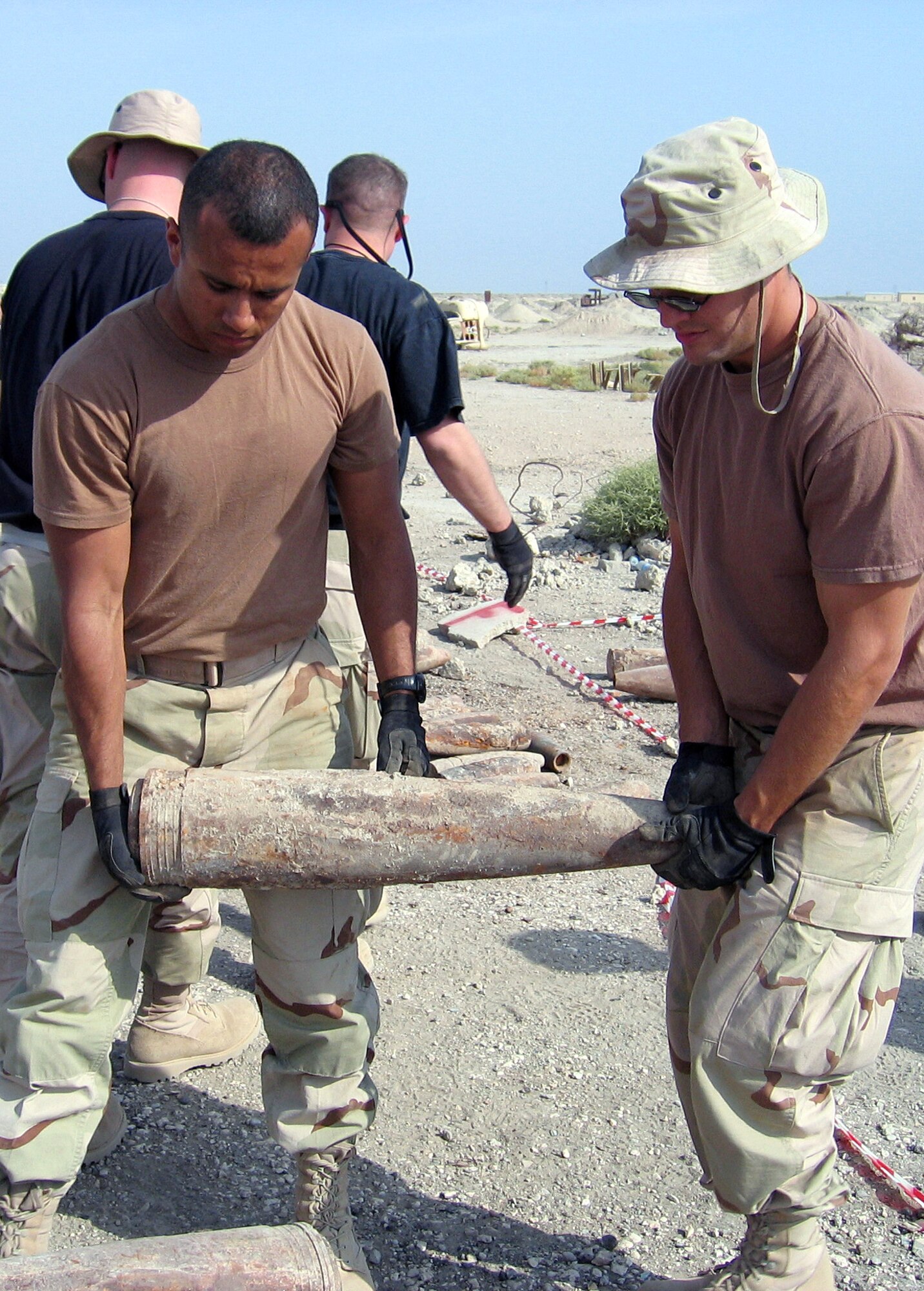 IRAQ (AFPN) -- Airman 1st Class Jorge Fernandez (left), Staff Sgt. Zach Terry and other volunteers move ordnance to Ali Base, Iraq. Both Airmen are assigned to the 407th Expeditionary Logistics Readiness Squadron. (U.S. Air Force photo by Master Sgt. Andrew C. Ferrell) 
