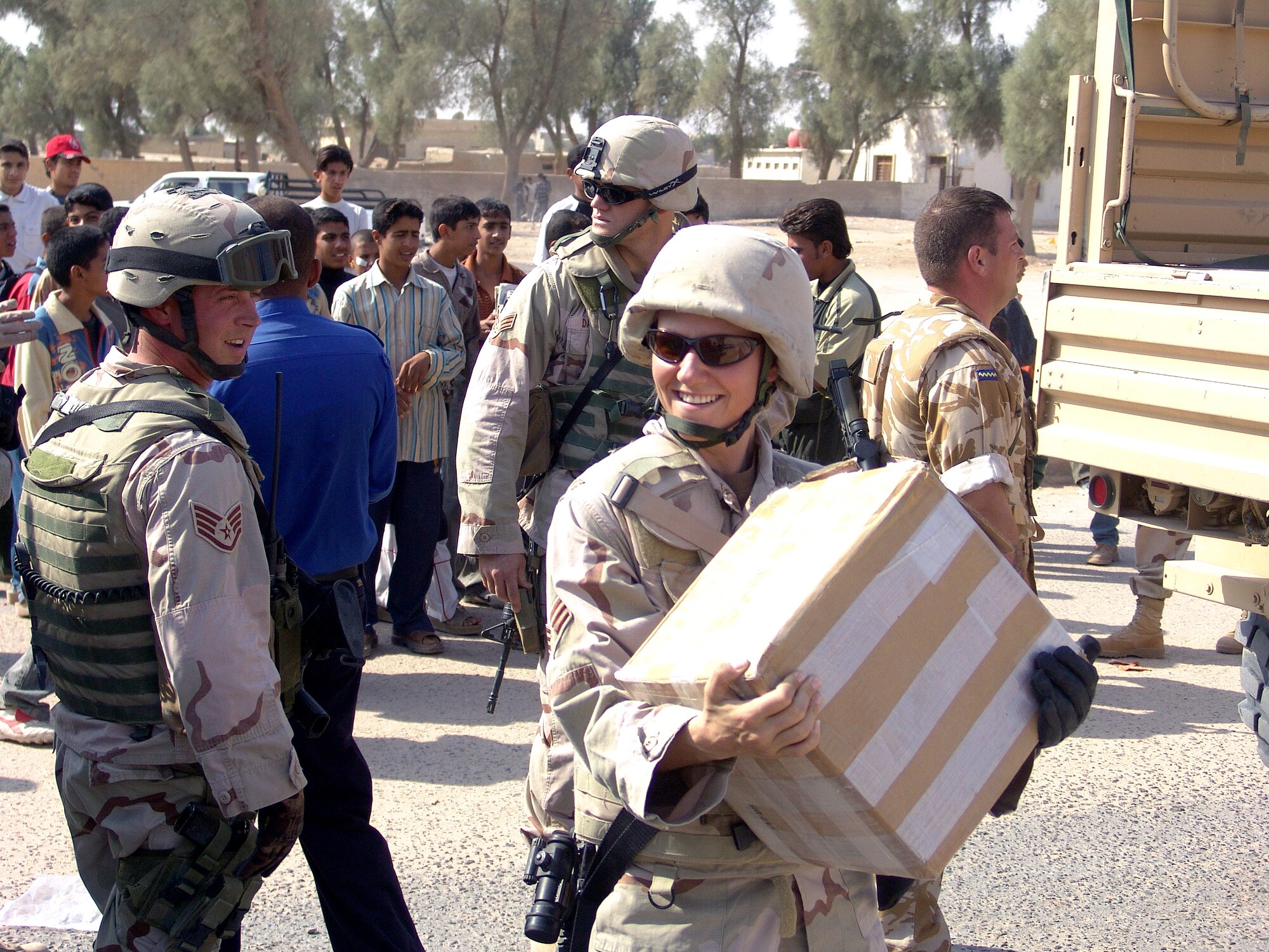 UMM QASR, Iraq (AFPN) -- Senior Airman Jana Sautter helps unload a truck full of school supplies during a humanitarian relief mission in Umm Qasr, Iraq. Coalition forces delivered more than a thousand school supplies and toys to the children Nov. 14. Airman Sautter is assigned to the 568th Expeditionary Security Forces Squadron. (U.S. Air Force photo by Capt. Michael G. Johnson)