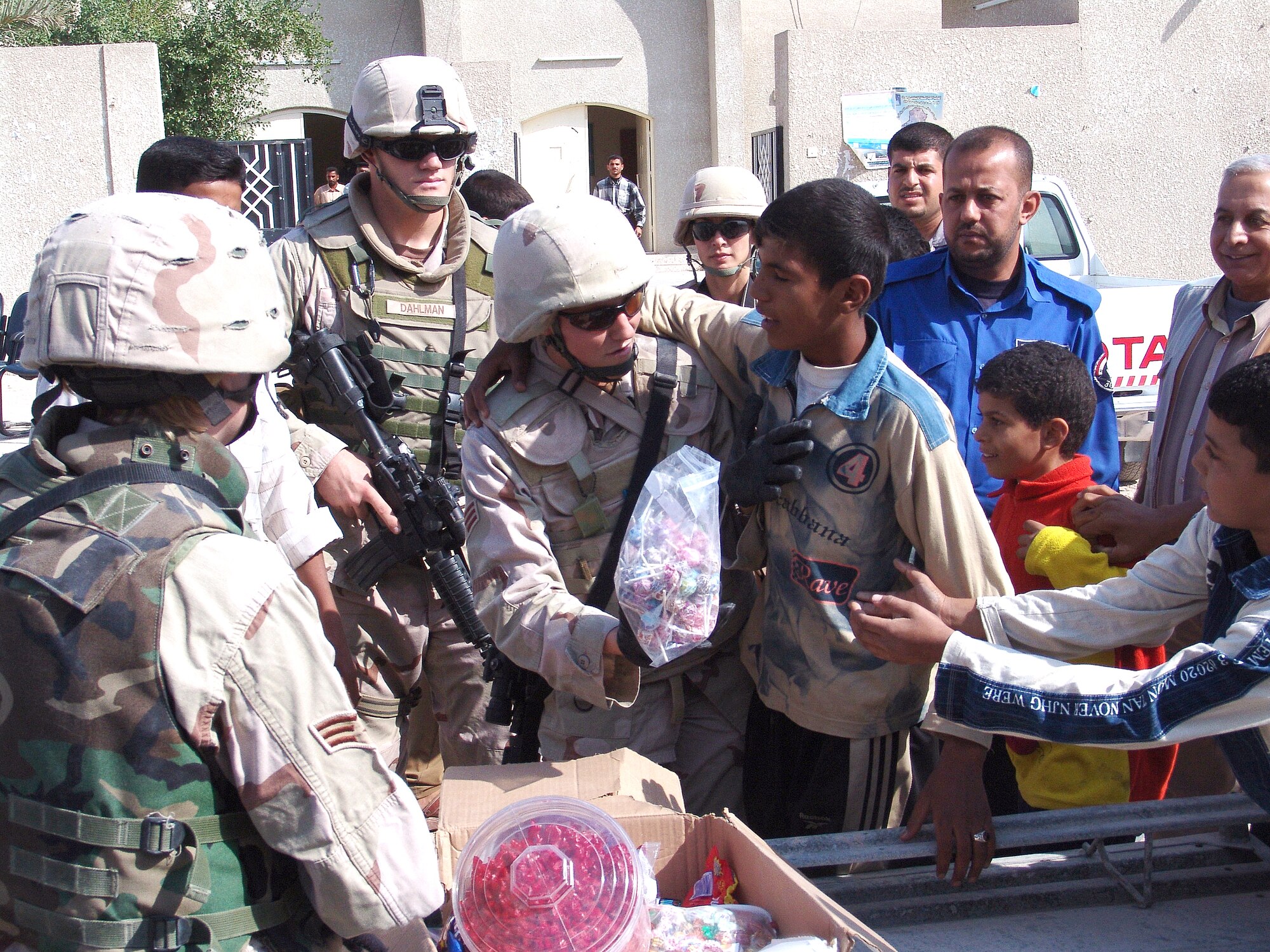 UMM QASR, Iraq (AFPN) -- Senior Airman Jana Sautter hands out some treats to Iraq children during a humanitarian relief mission in Umm Qasr, Iraq. Coalition forces delivered more than a thousand school supplies and toys to the children Nov. 14. Airman Sautter is assigned to the 568th Expeditionary Security Forces Squadron. (U.S. Air Force photo by Capt. Michael G. Johnson)