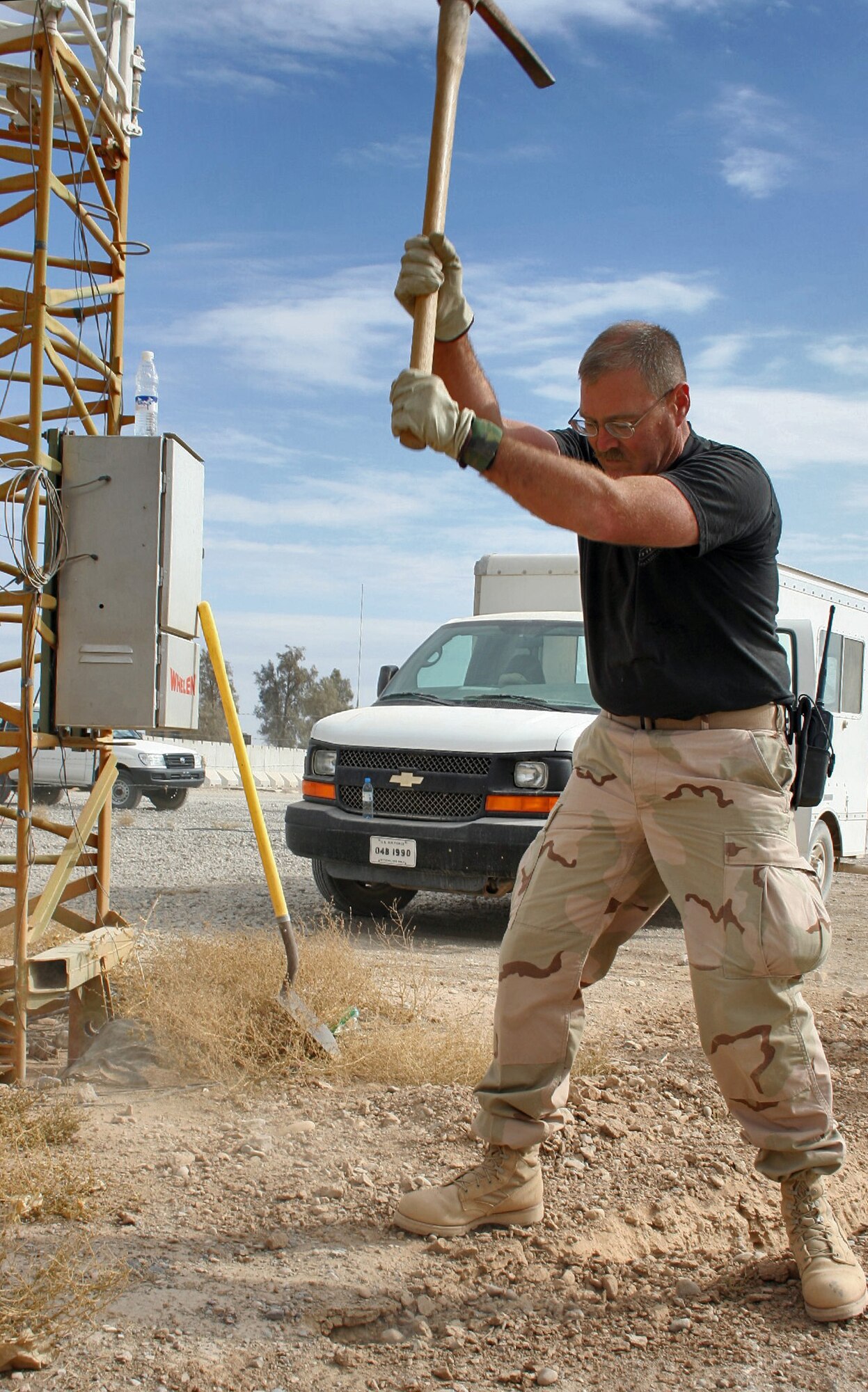 KANDAHAR AIR FIELD, Afghanistan (AFPN) -- Master Sgt. Richard Poole helps dig a ditch for relocating 2,400 feet of radar fiber and computer network and phone cable. As U.S. forces prepare to return the airport terminal and tower to Afghan control, combat communicators have installed more than a mile of copper and fiber cabling. Sergeant Poole is the 451st Air Expeditionary Group support communications section noncommissioned officer in charge of maintenance. Sergeant Poole is an Air National Guardsman deployed from Hot Springs Memorial Air Field in Hot Springs, Ark. (U.S. Air Force photo by Staff Sgt. Marcus McDonald) 
