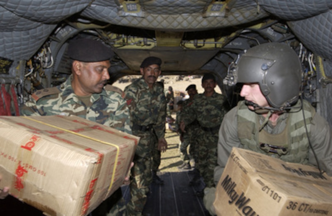 Army Spc. Thaddeus Spencer (right) helps Pakistani soldiers unload humanitarian relief supplies from a U.S. Army CH-47D Chinook helicopter in Darband, Pakistan, on Nov. 16, 2005. The Department of Defense is supporting the State Department by providing disaster relief supplies and services following the massive earthquake that struck Pakistan and parts of India and Afghanistan. 