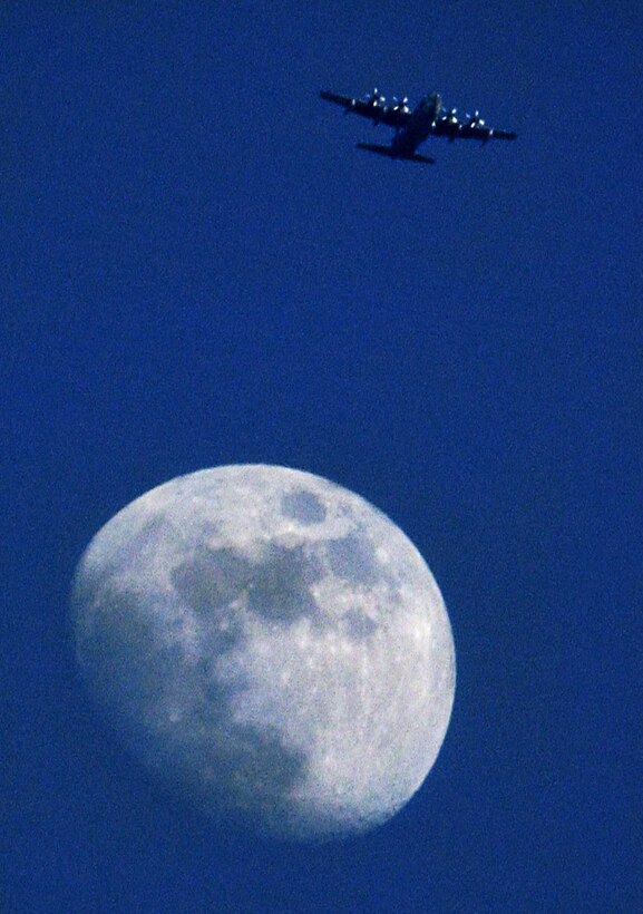 CAMP LEMONIER, Djibouti (AFPN) -- A C-130 Hercules of the 131st Rescue Squadron flies high over the Golf Drop Zone  -- and seemingly over the moon -- near this camp in the Horn of Africa. (U.S. Air Force photo by Staff Sgt. Stacy L. Pearsall)
