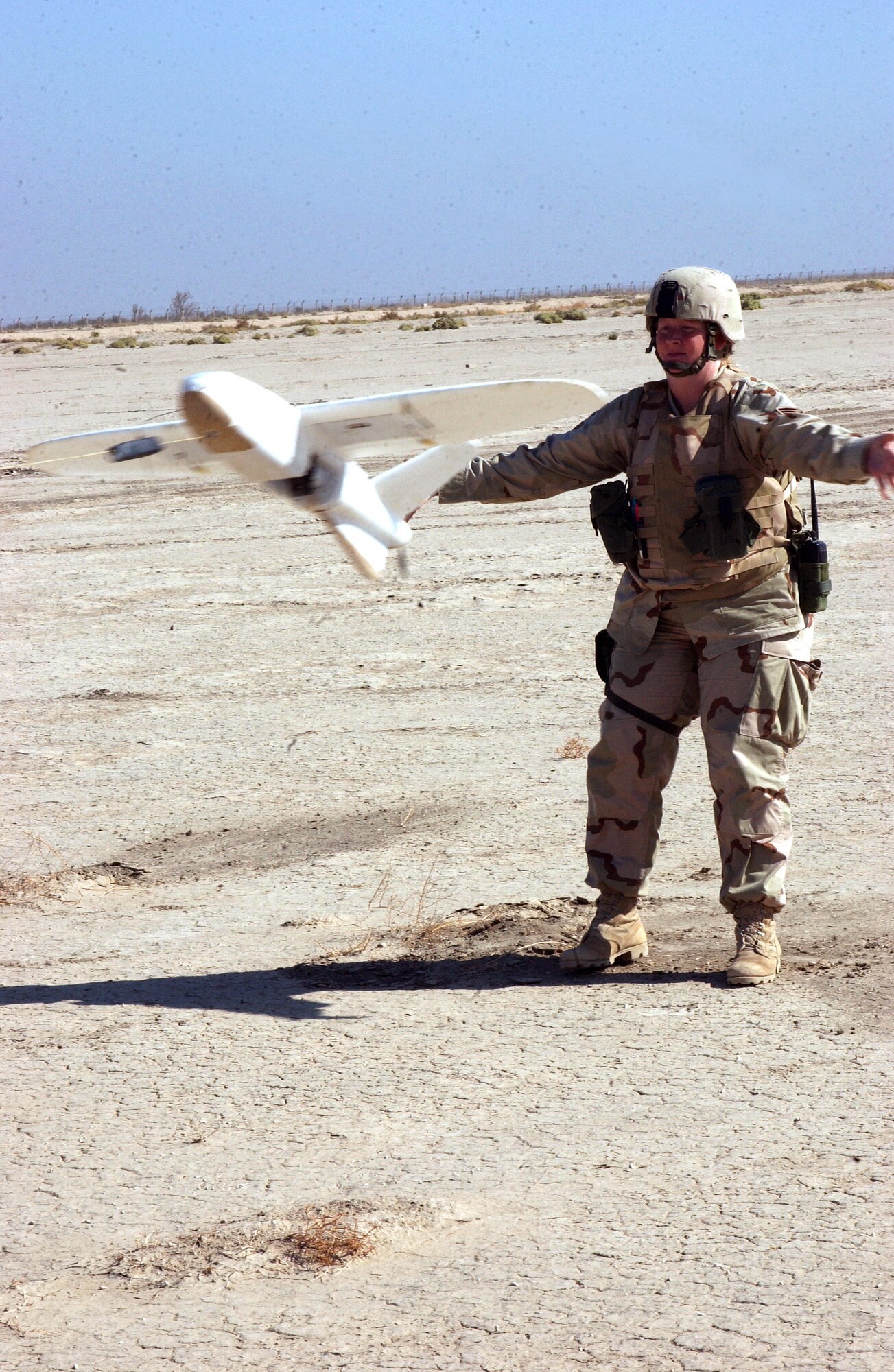 ALI BASE, Iraq (AFPN) -- Senior Airman JoAnn Bonzi releases a miniature unmanned aerial vehicle. The UAV is tied to a bungee cord stretched between the mission "pilot" and "copilot" during a slingshot takeoff. The motor starts automatically when it reaches a predetermined speed. Airman Bonzi was a copilot for this mission. (U.S. Air Force photo by Tech. Sgt. Paul Dean) 