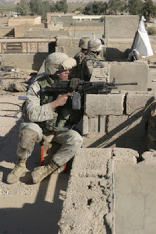 A U.S. Marine and Iraqi Army soldiers watch over the surrounding streets from a rooftop in Karabilah, Iraq, during Operation Steel Curtain on Nov. 11, 2005. The intent of Steel Curtain is to restore Iraqi sovereign control along the Iraq-Syria border and destroy the al Qaeda network operating throughout the Qaim region. 