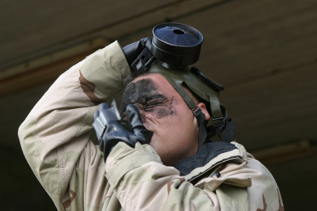 Lance Cpl. Jason A. Salas, PMO, rubs M-291 skin decon over his face during a demonstration at the